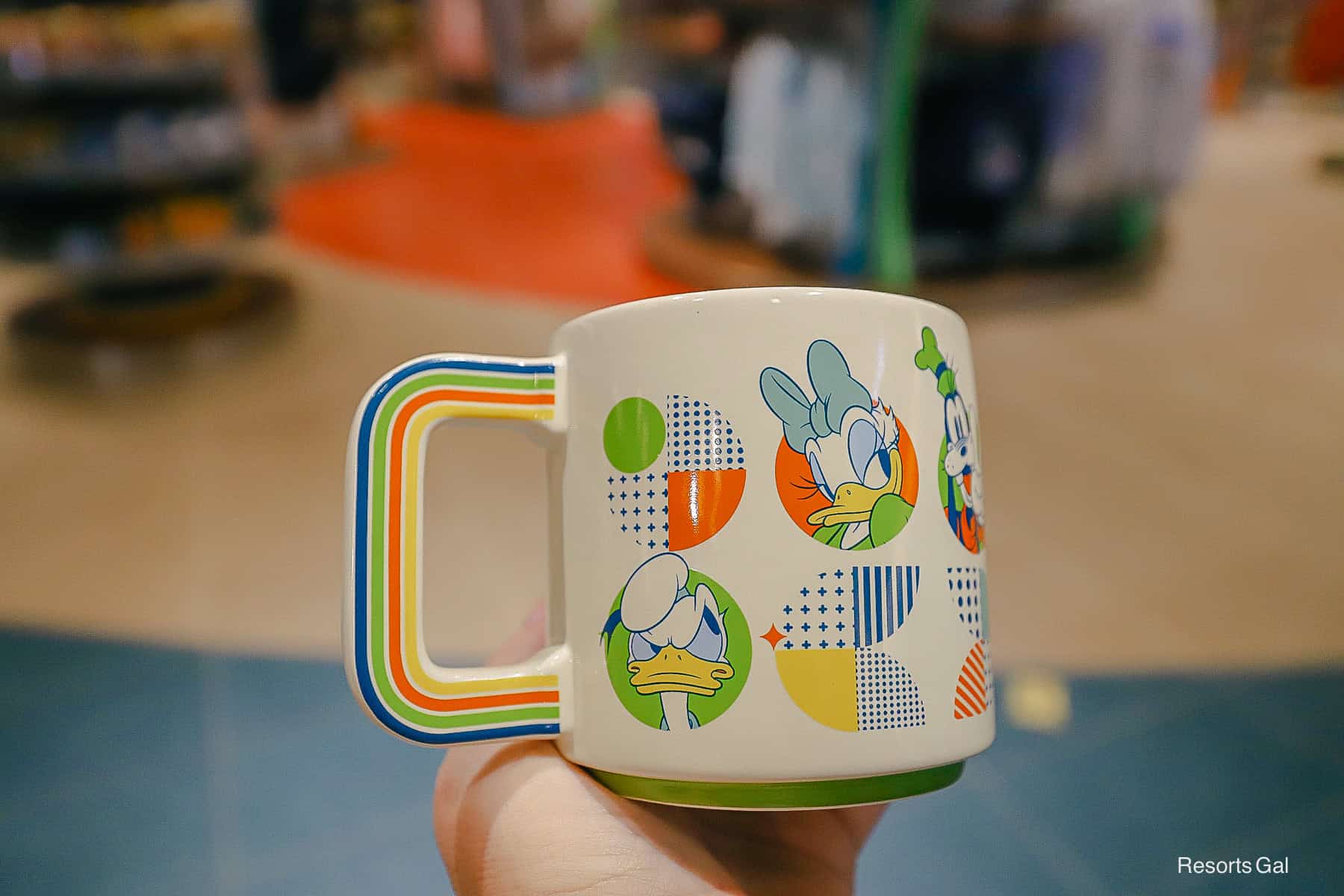a mug's handle with blue, green, orange, and yellow stripes