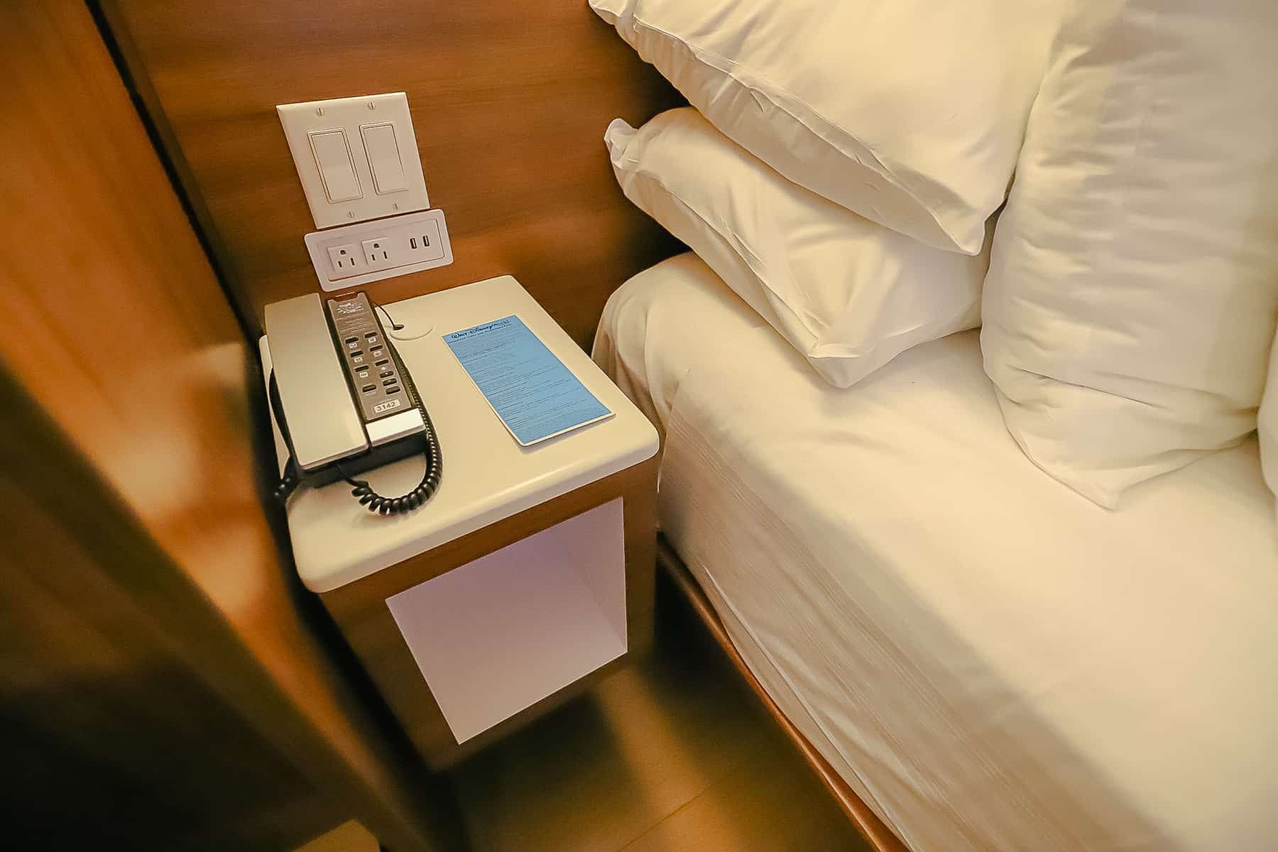 a nightstand with a telephone and cubby hole 