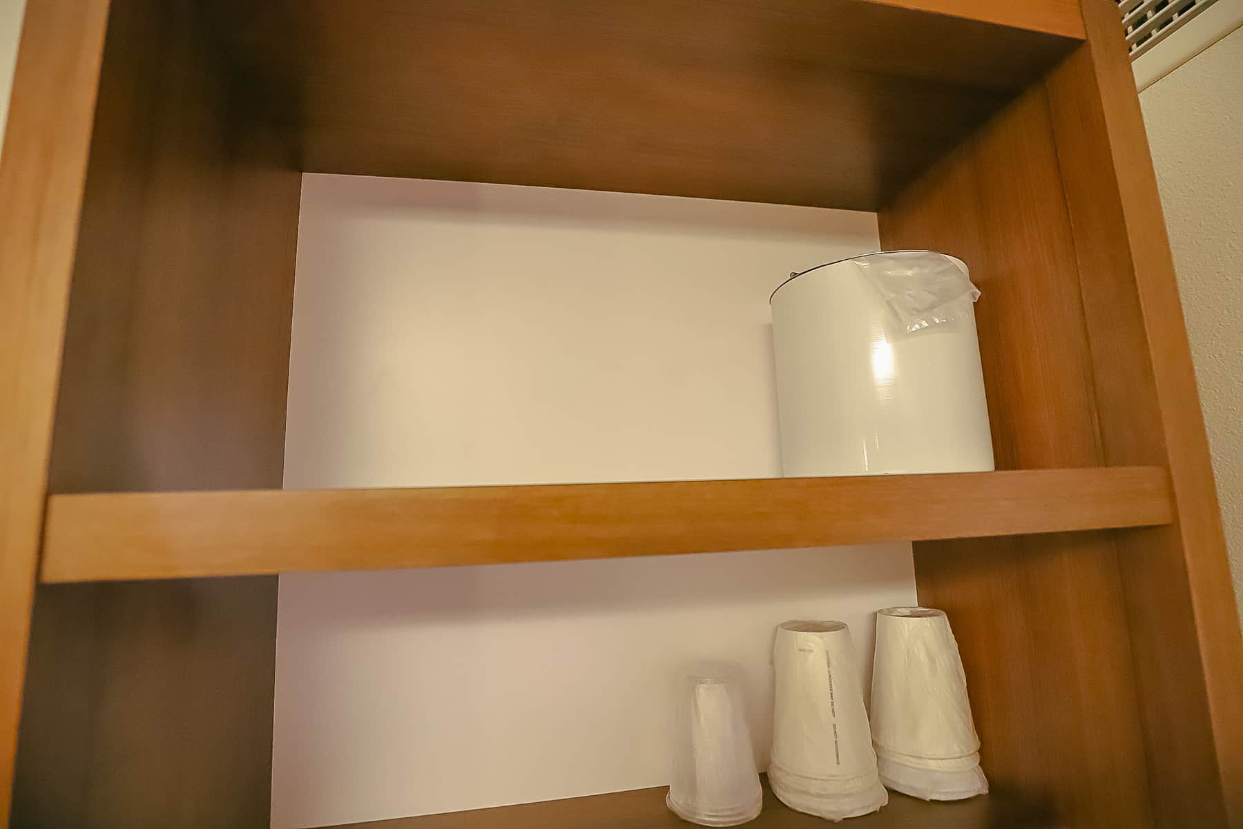 ice bucket and cups sitting on shelves 