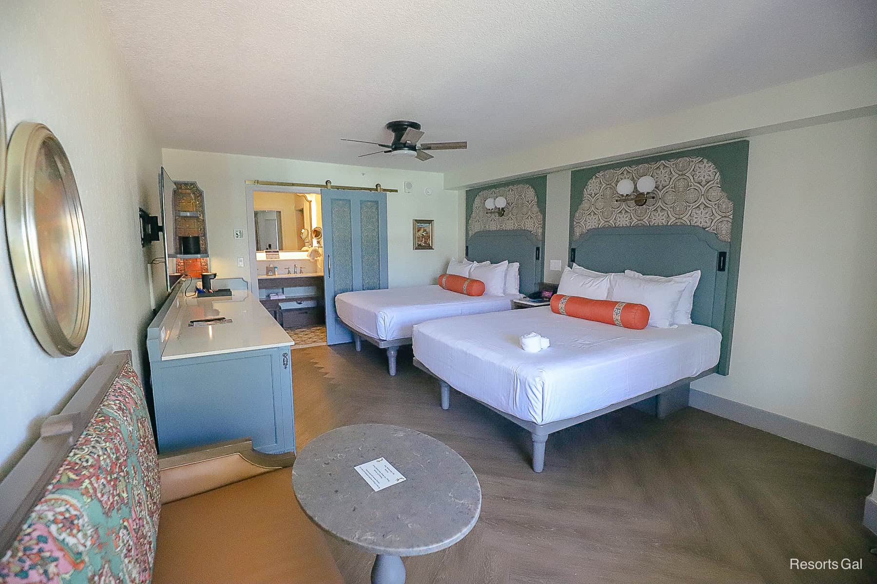 a hotel room with two beds and a mini sofa with table