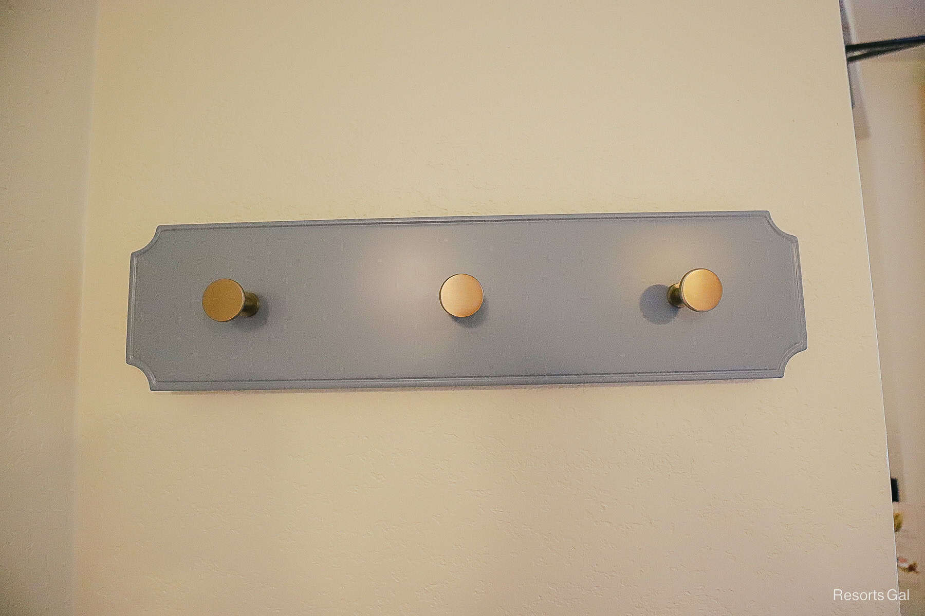a wall mount with three hooks to hang items