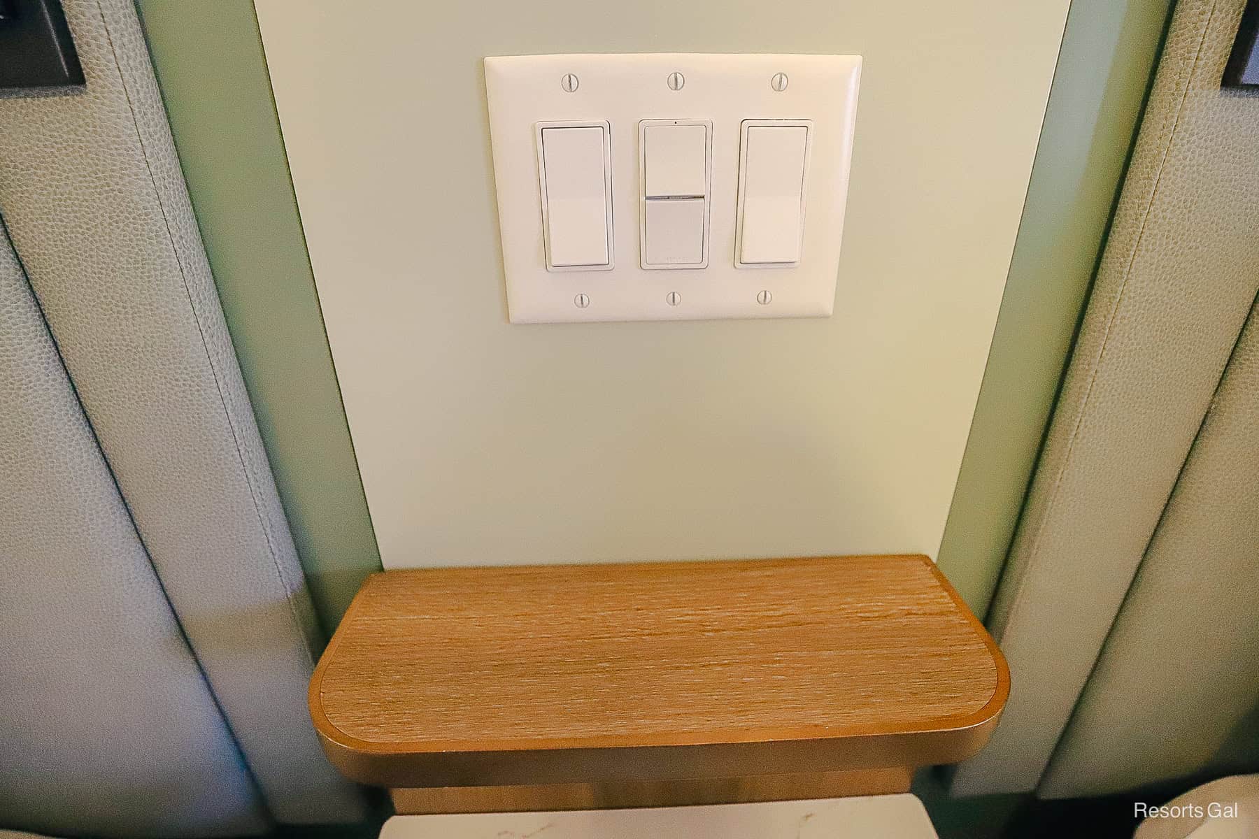 a trio of switches for lights and the ceiling fan that can be turned on from the bed
