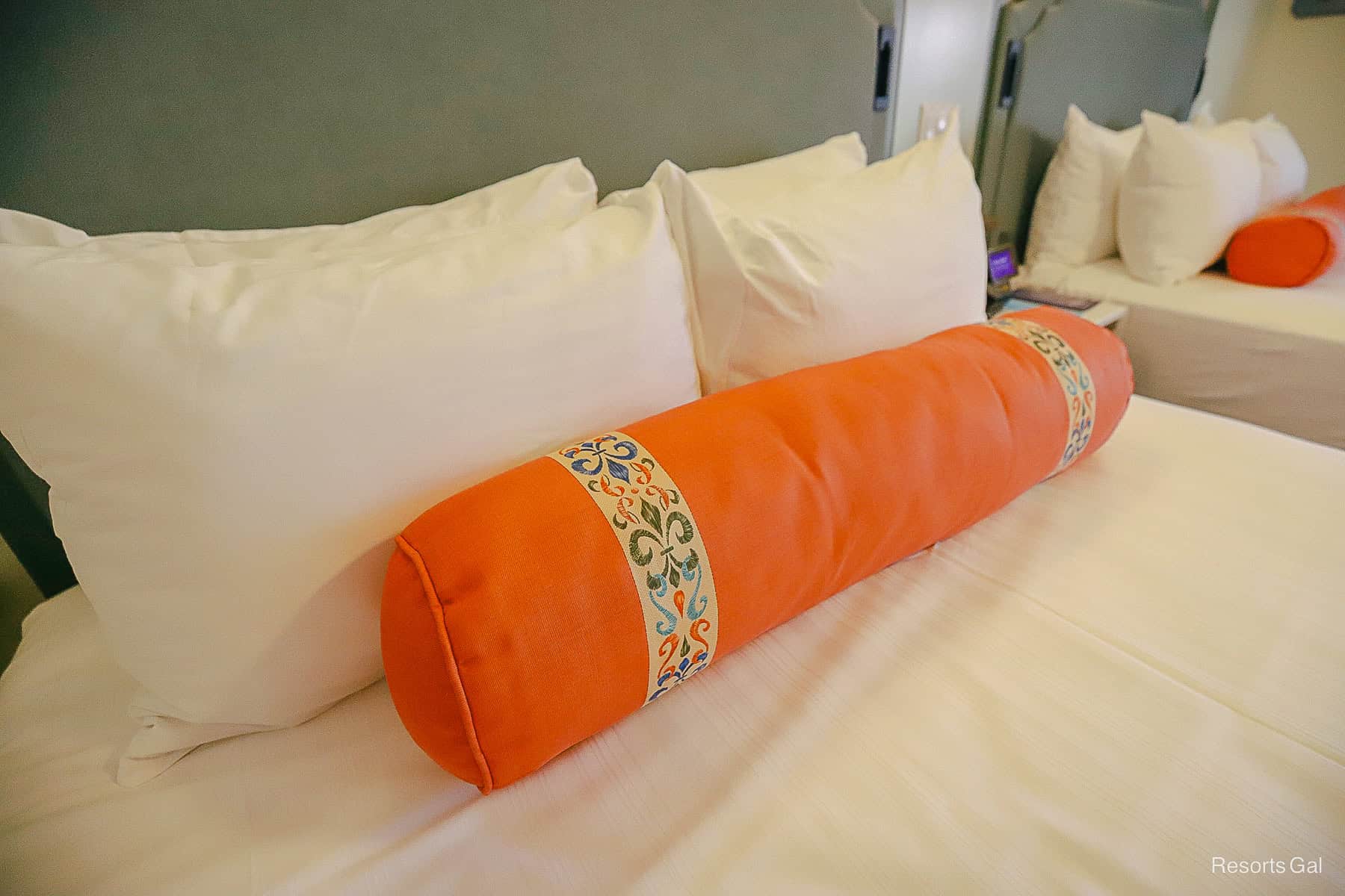a bright orange pillow shaped like a log