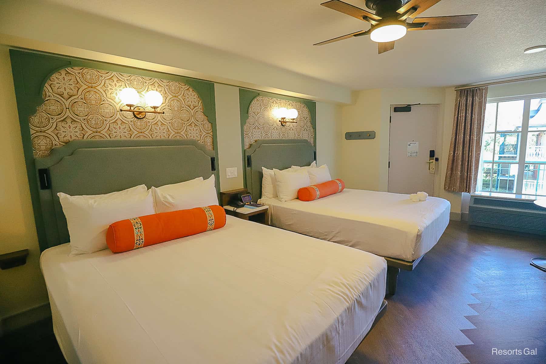 two queen beds with bright orange roll pillows