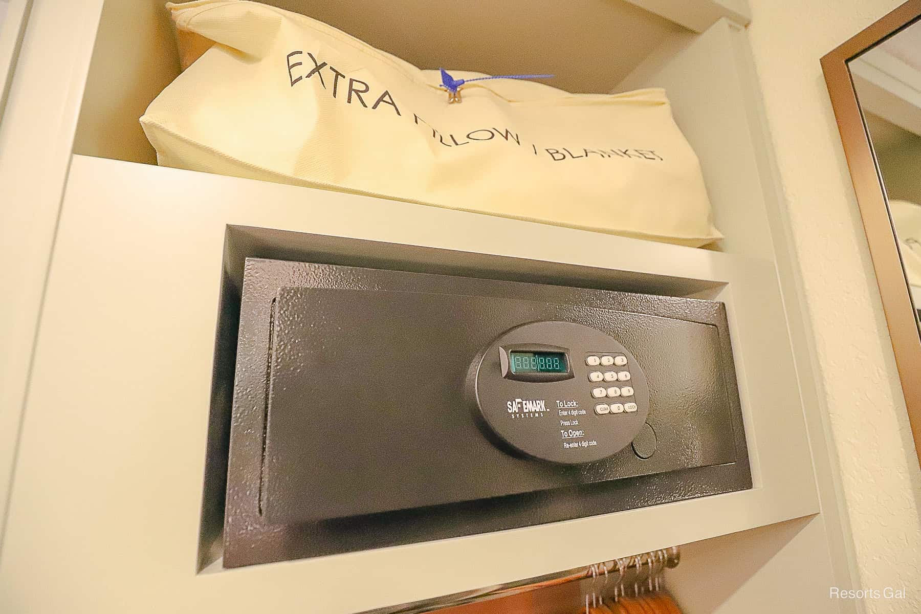 the in room safe and an extra pillows and blanket above it