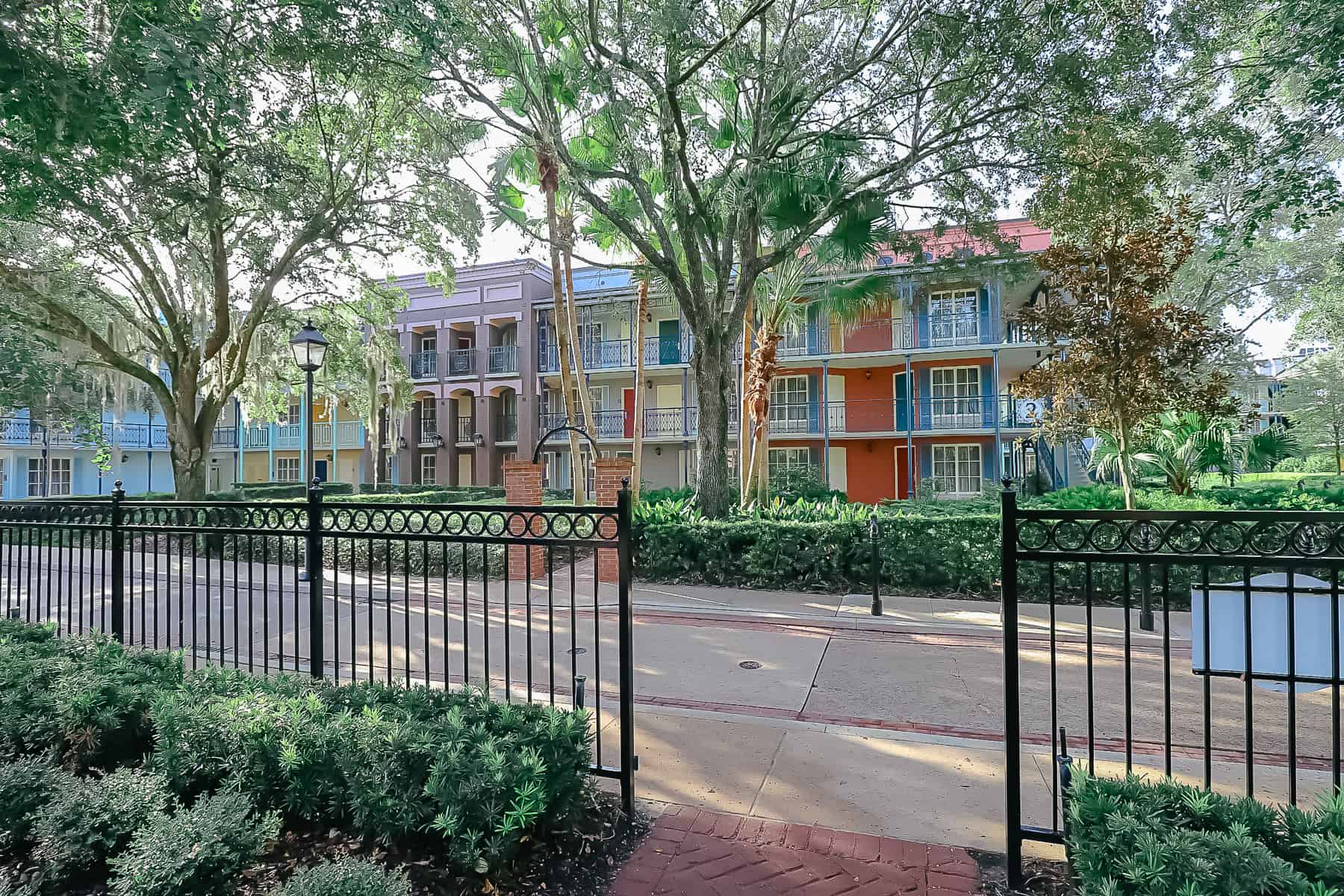 The French Quarter with black iron gates, paver walkways and bright buildings. 