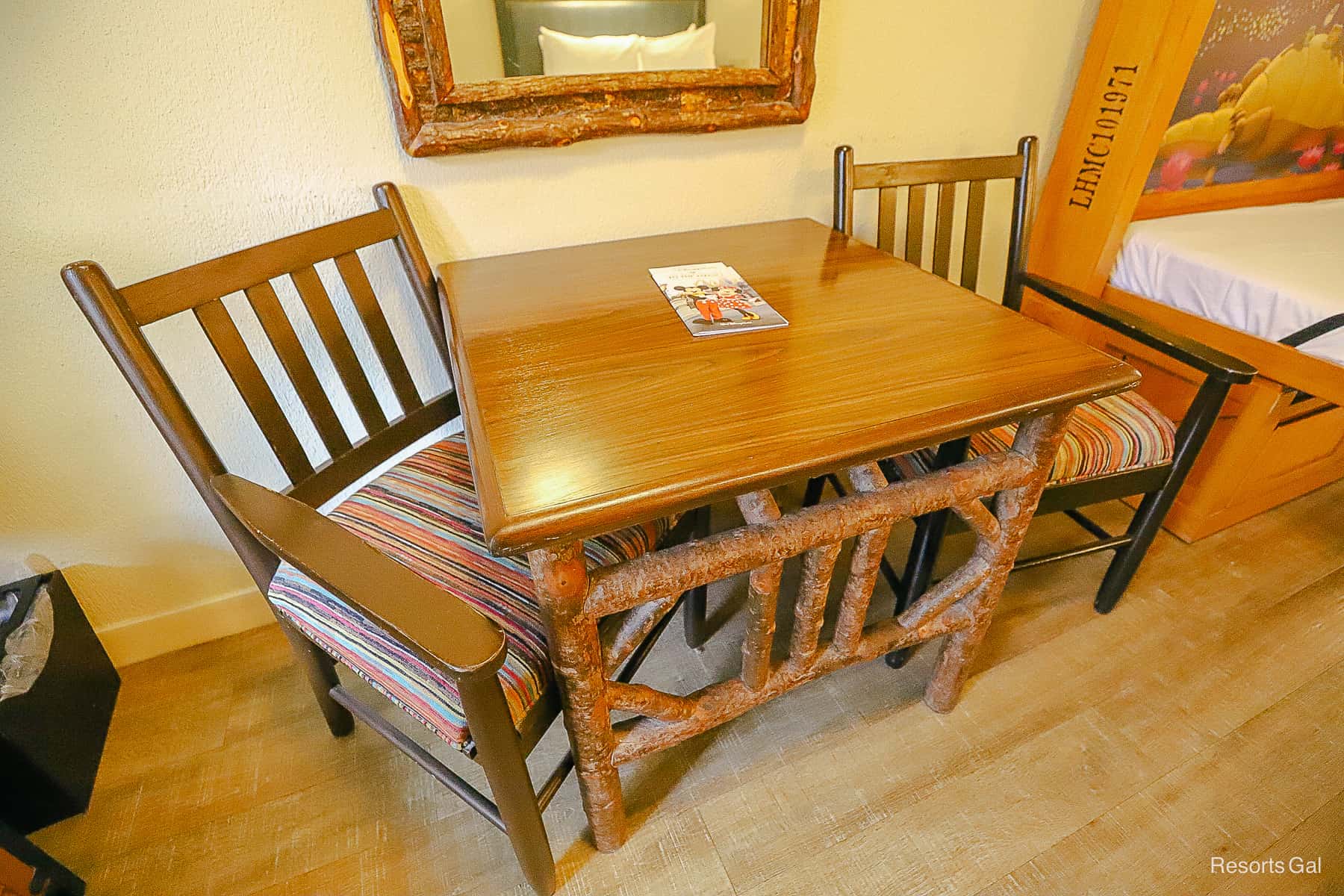 A table and two chairs with wooden accents. 