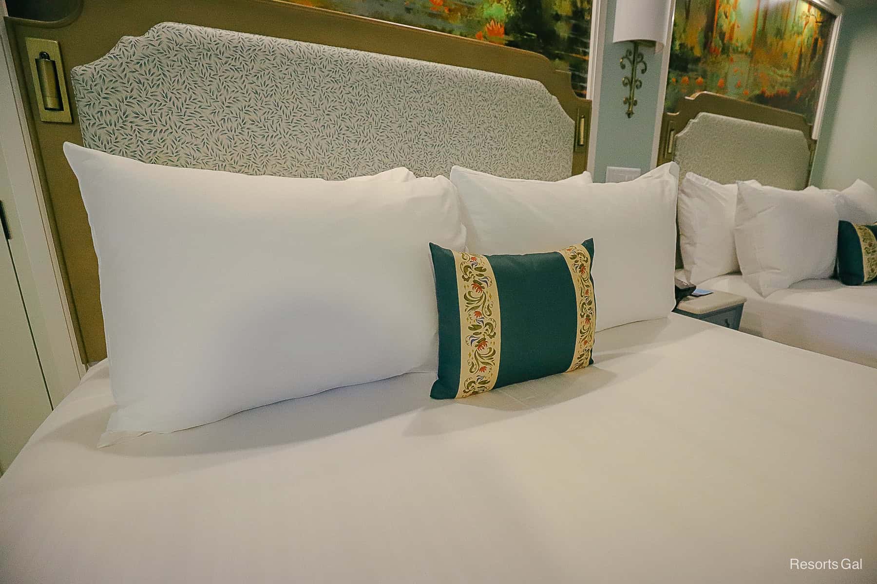 a decorative pillow in front of four regular pillows on the bed