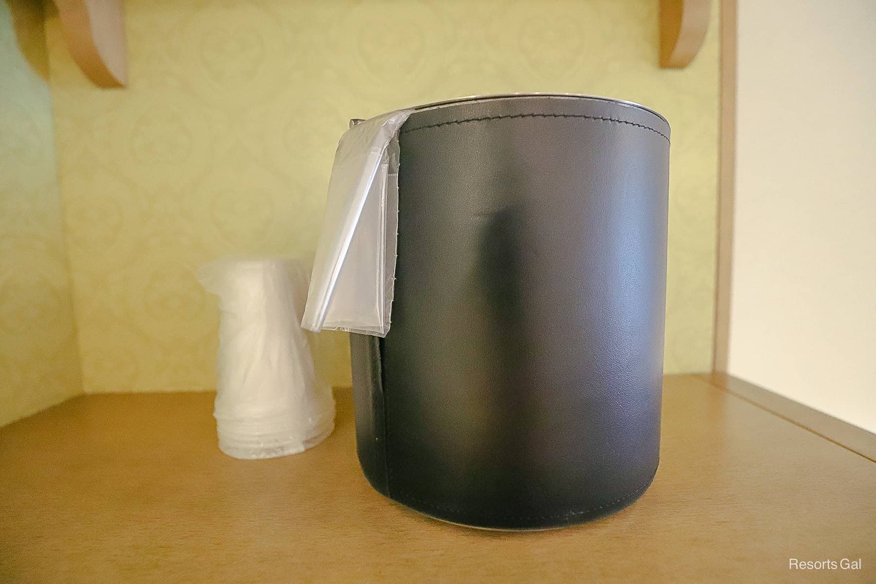 an ice bucket on a shelf with plastic cups in the updated rooms at Port Orleans Riverside