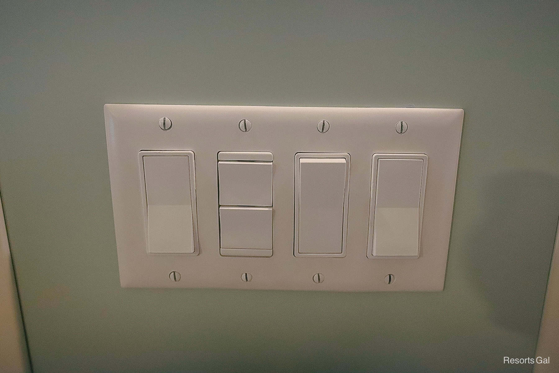 a panel of light switches between the bed