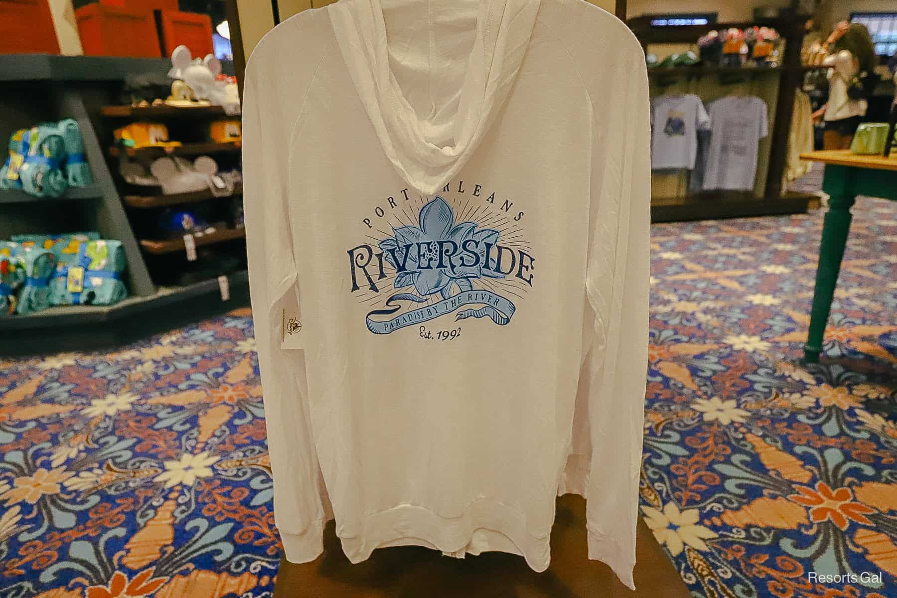 Port Orleans Riverside logo with a magnolia on a light white pullover with sleeves and a hoodie