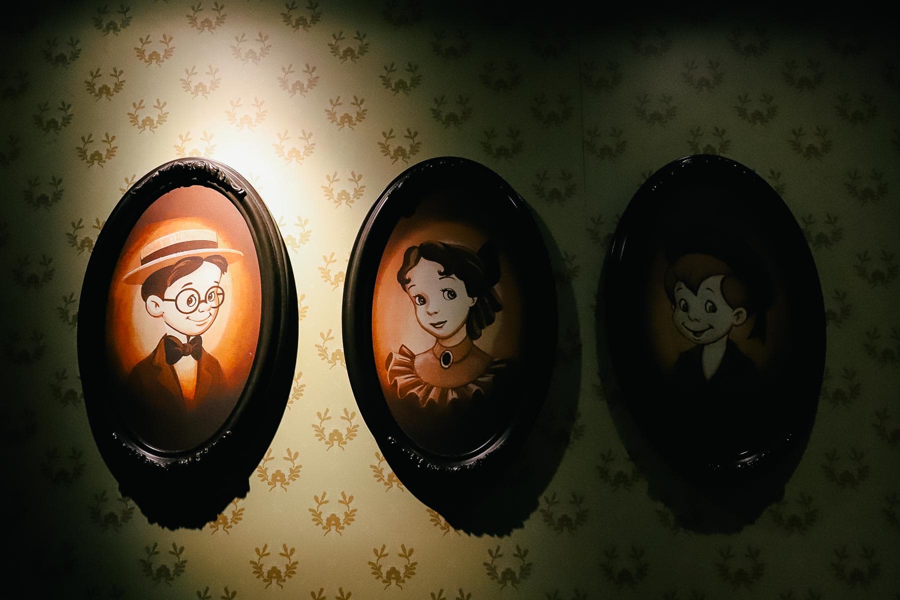 Portraits of Jon, Michael,and Wendy hang on the wall of the Darling House in the queue for the ride. 