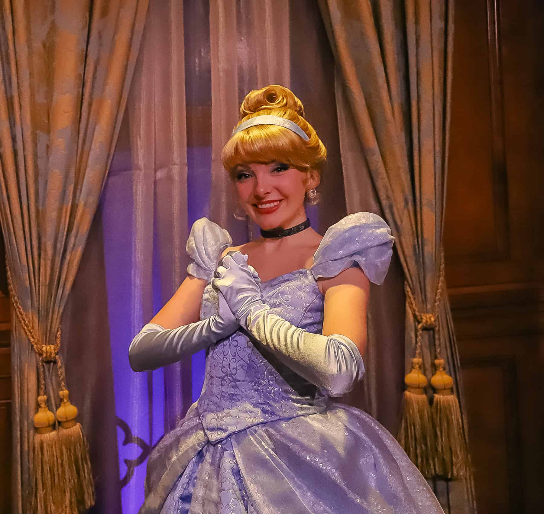 Cinderella poses with hands clasped. 