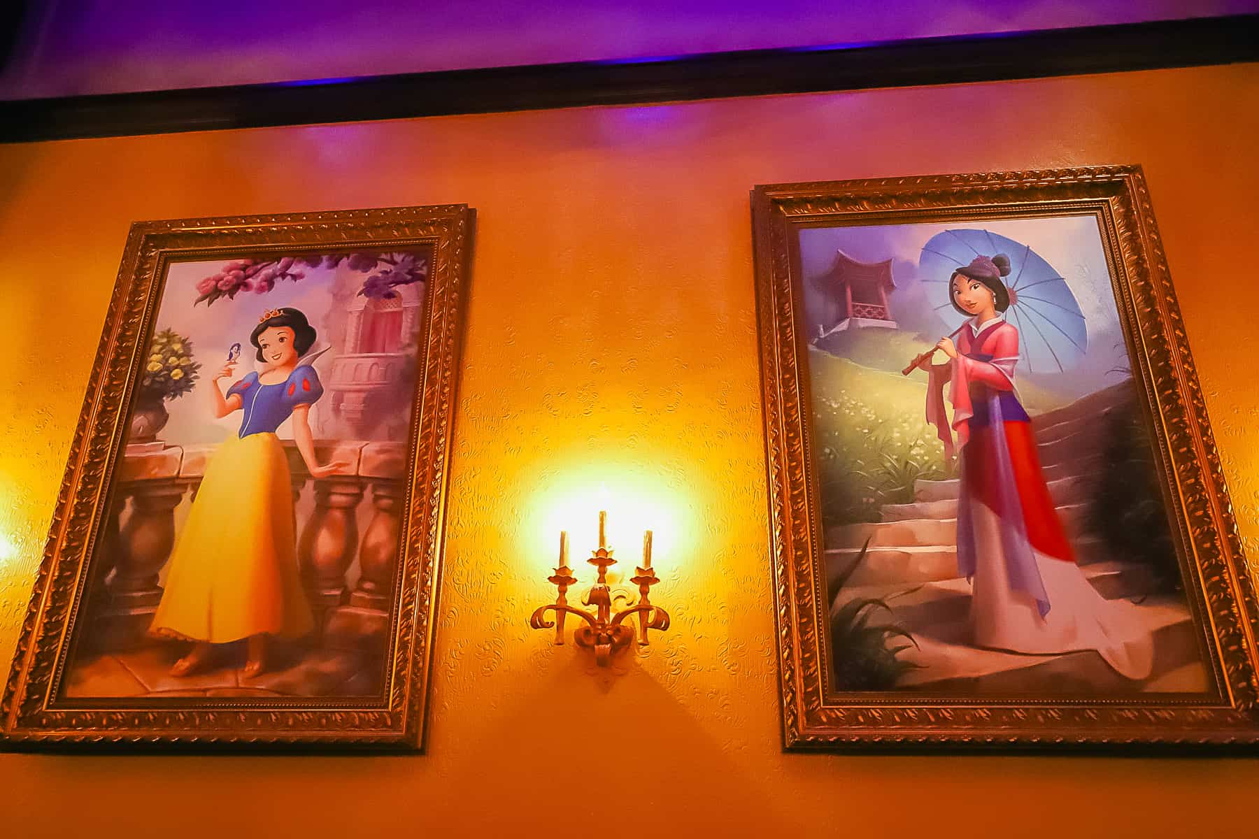 Portraits of princesses Snow White and Mulan hang inside Princess Fairytale Hall. 
