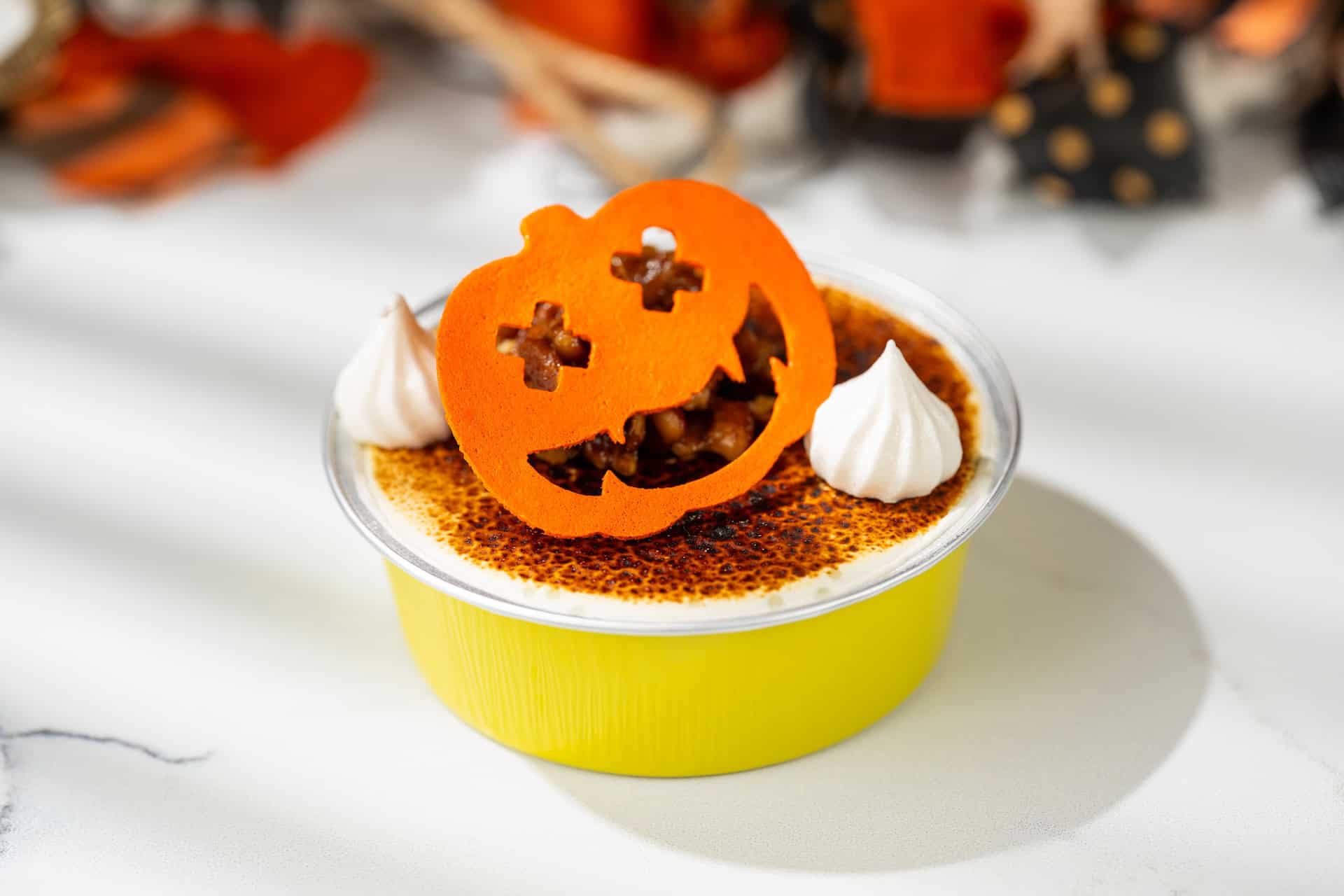 a pumpkin-shaped dessert with dollops of whip cream