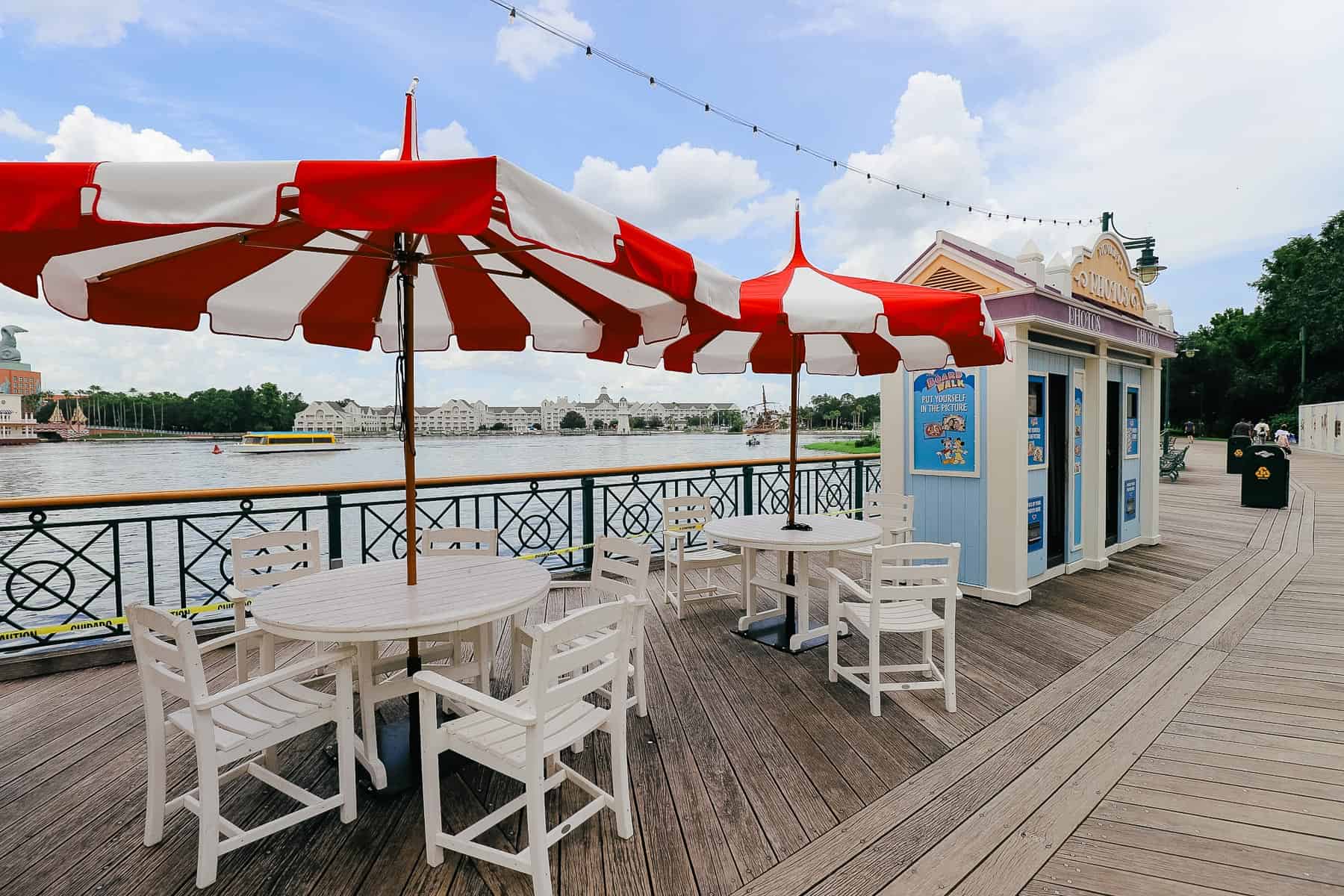 white tables with bright red and white striped umbrellas on Disney's Boardwalk 