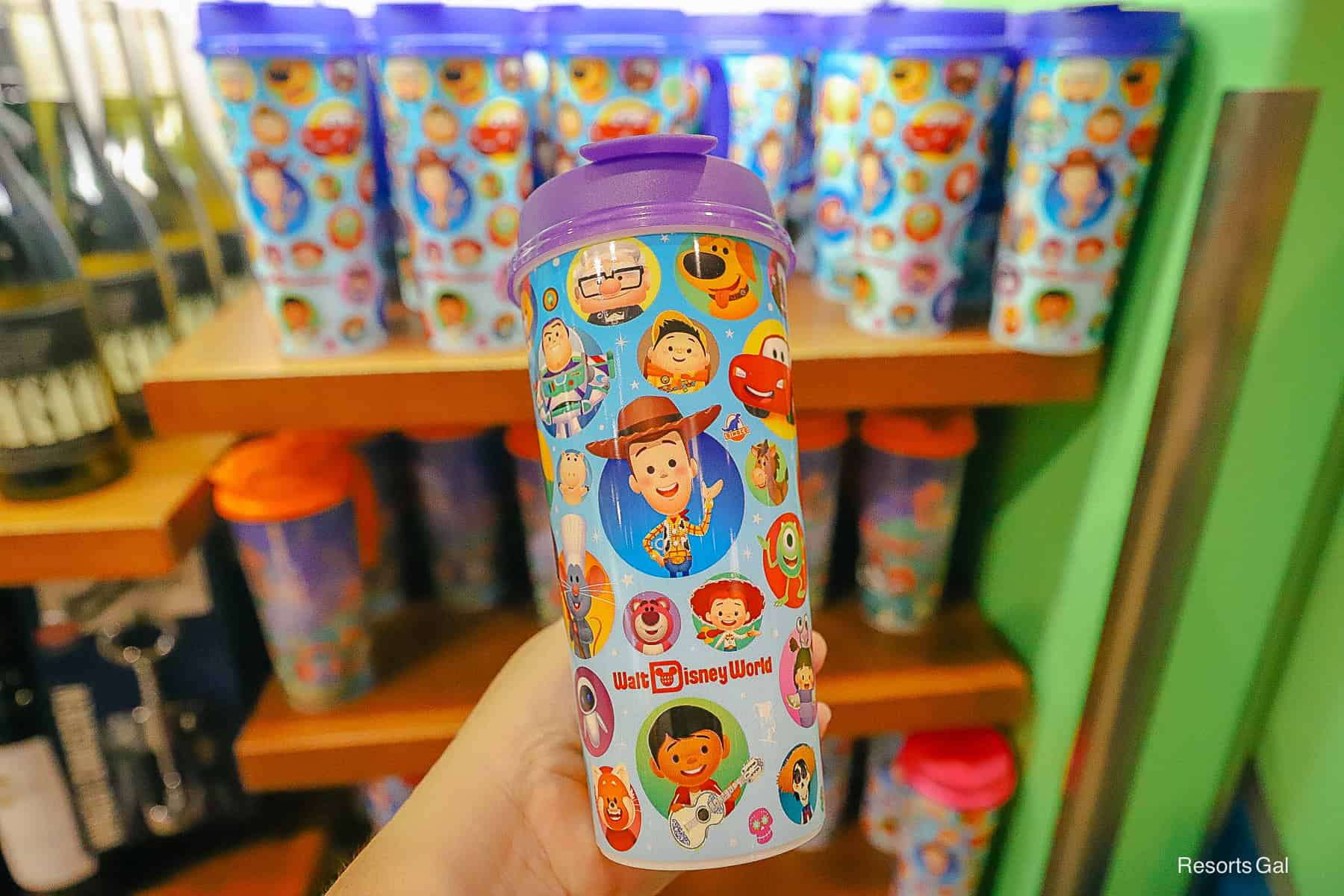a new refillable mug design with Pixar characters and the Walt Disney World logo in red and a purple top 