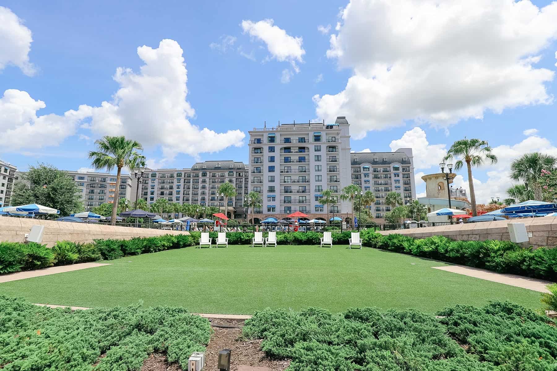 shows the lawn and the umbrellas from the pool behind it 