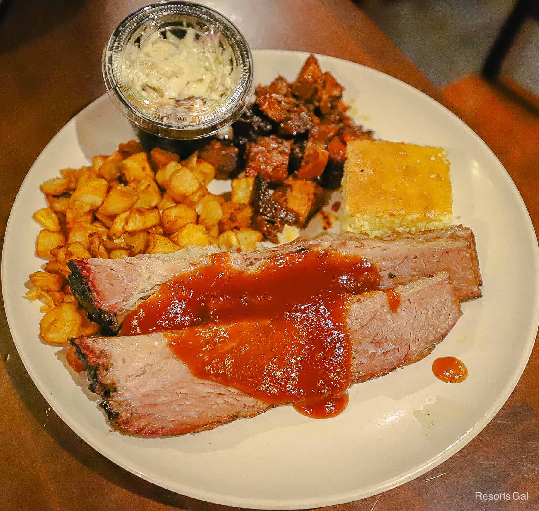 a white plate with brisket, potato hash, slaw and cornbread from Roaring Fork 