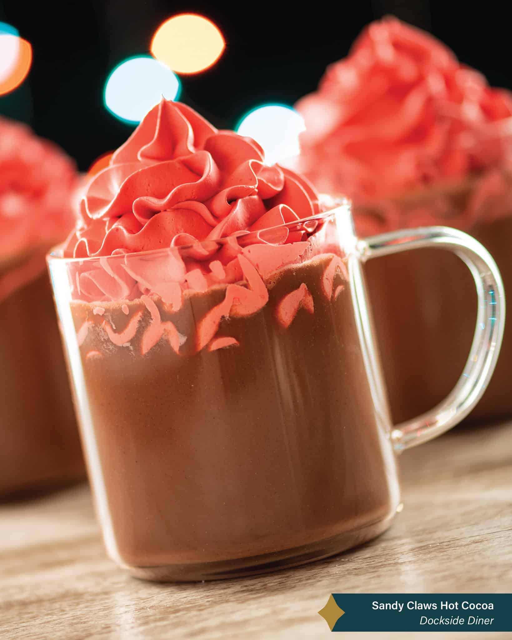 a glass of hot chocolate topped with red icing and foam