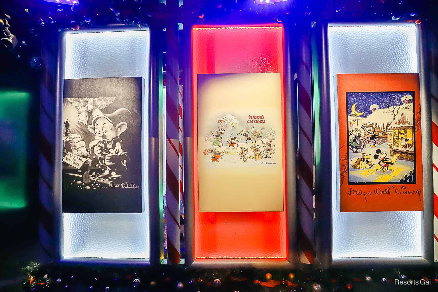 holiday paintings line the wall of the queue 