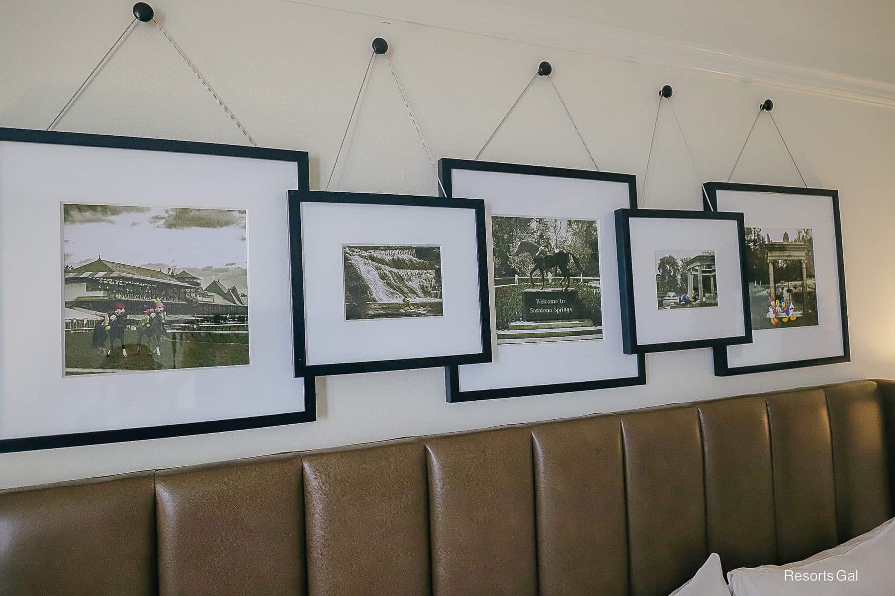 a group of black and white paintings displayed over the king size bed