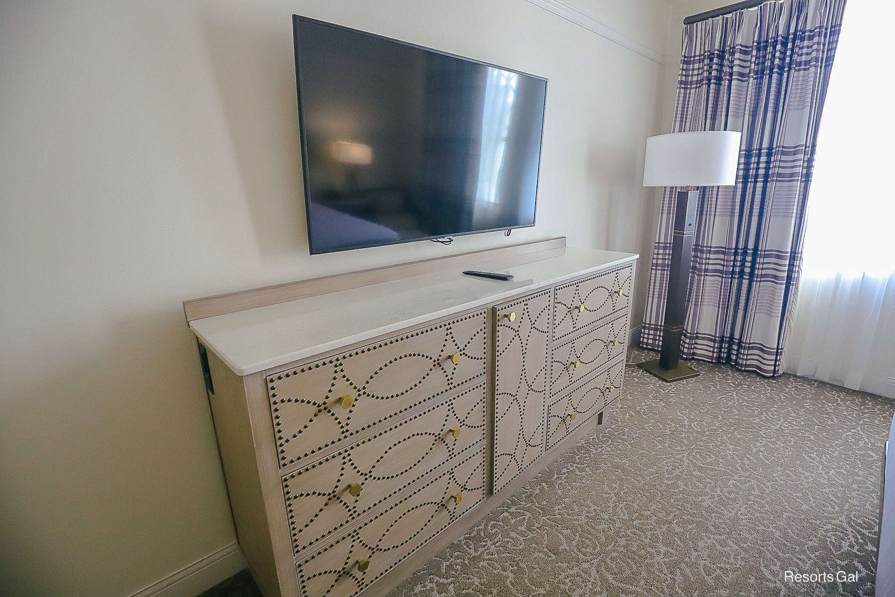 a dresser with flat-screen television above it