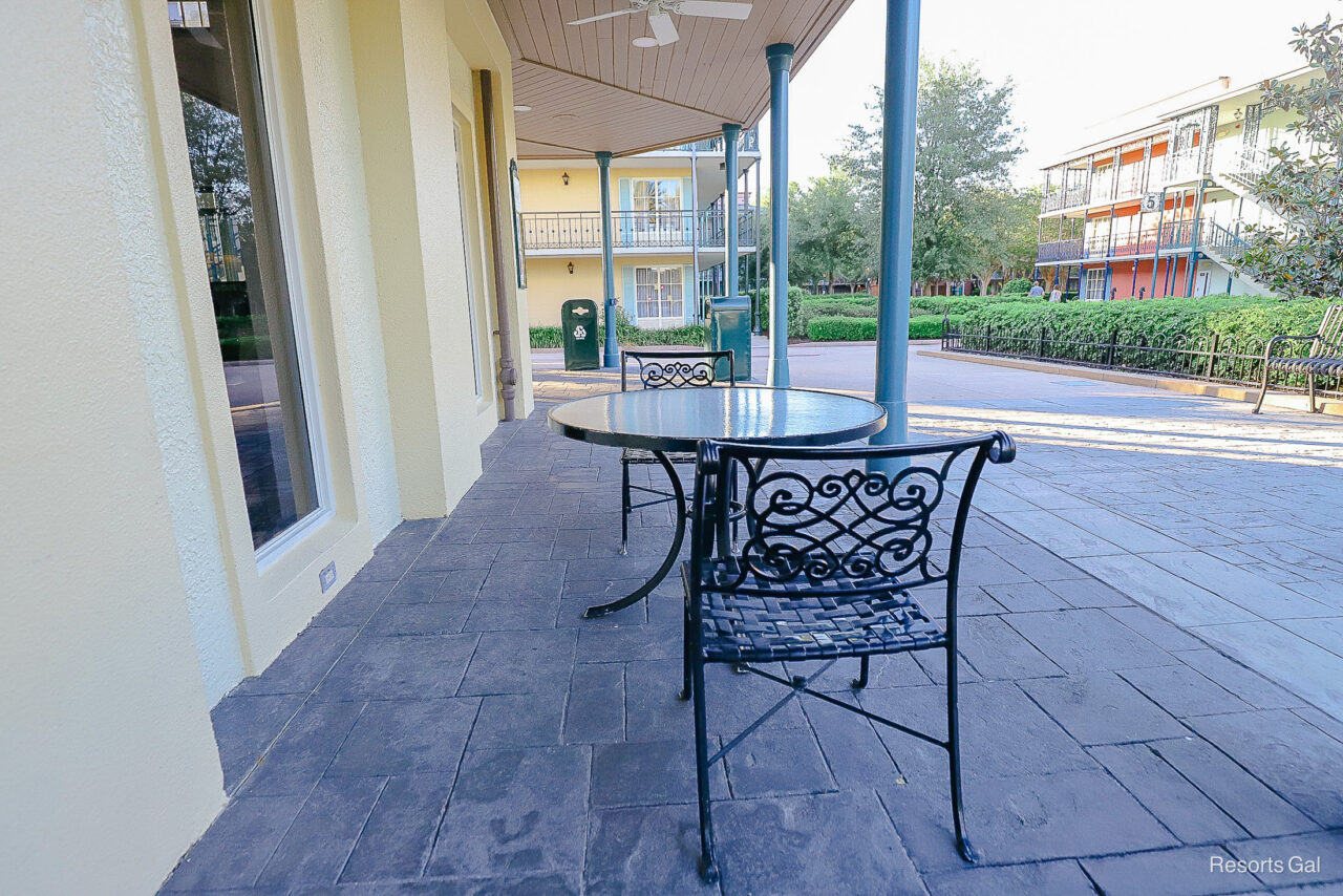 an outdoor eating area with small tables and chairs for two