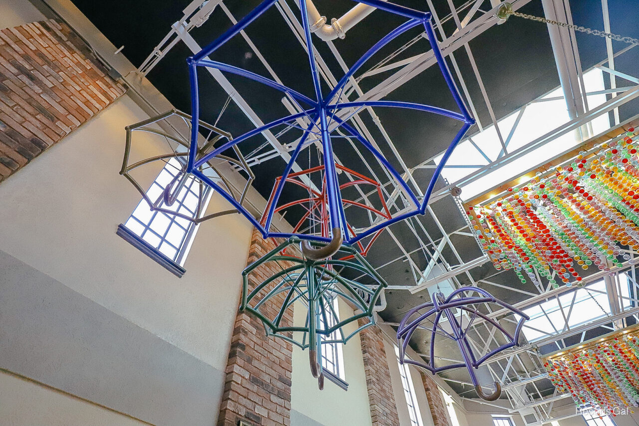 metal frame umbrellas hanging from the ceiling in blues, reds, and greens