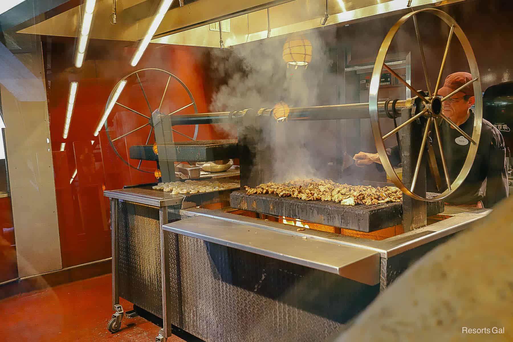 a cast member roasting beef and chicken on the grill at Satu'li Canteen 