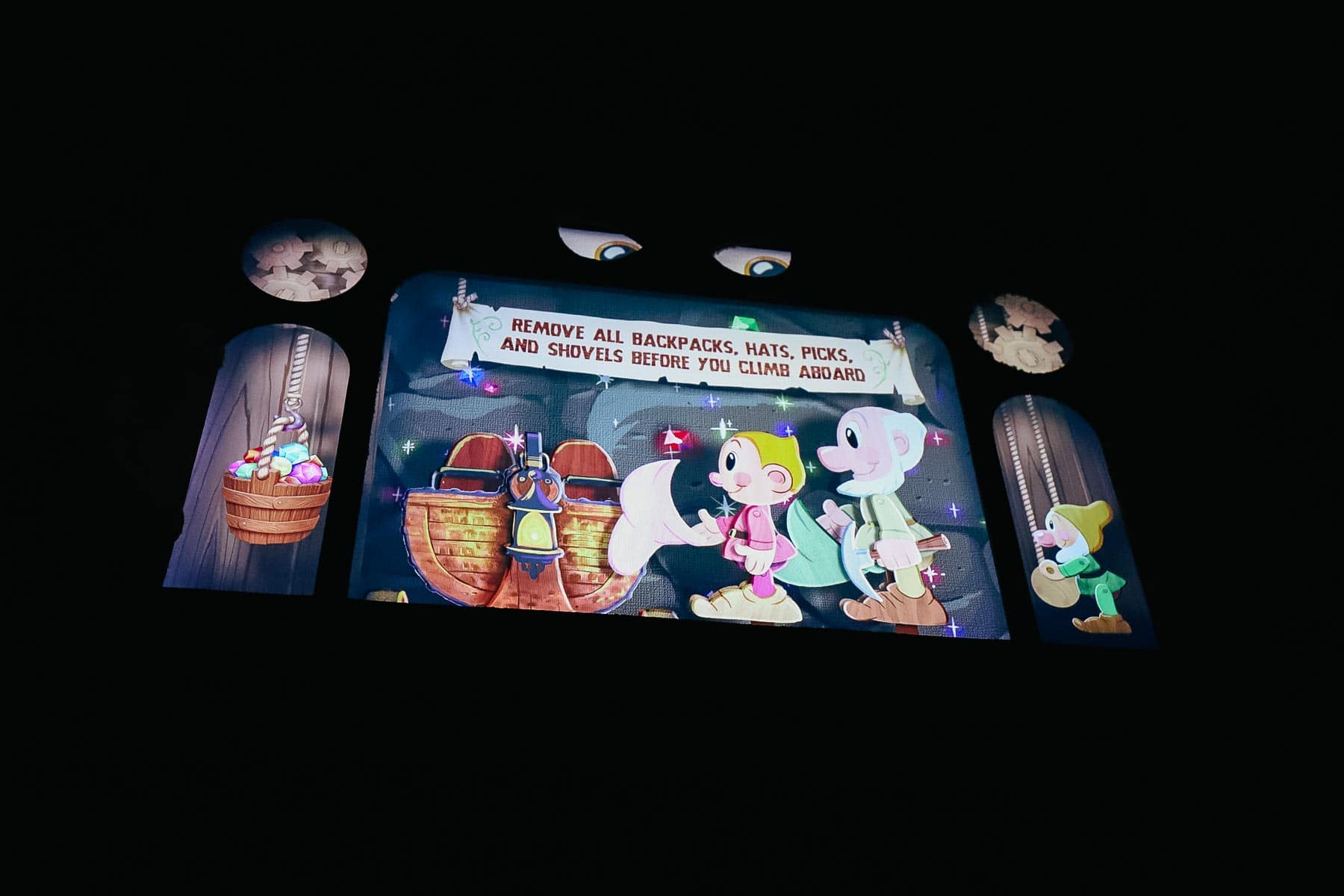 A screen that shares the ride's boarding process. It reads, "Remove all backpacks, hats, picks, and shovels before you climb aboard." 
