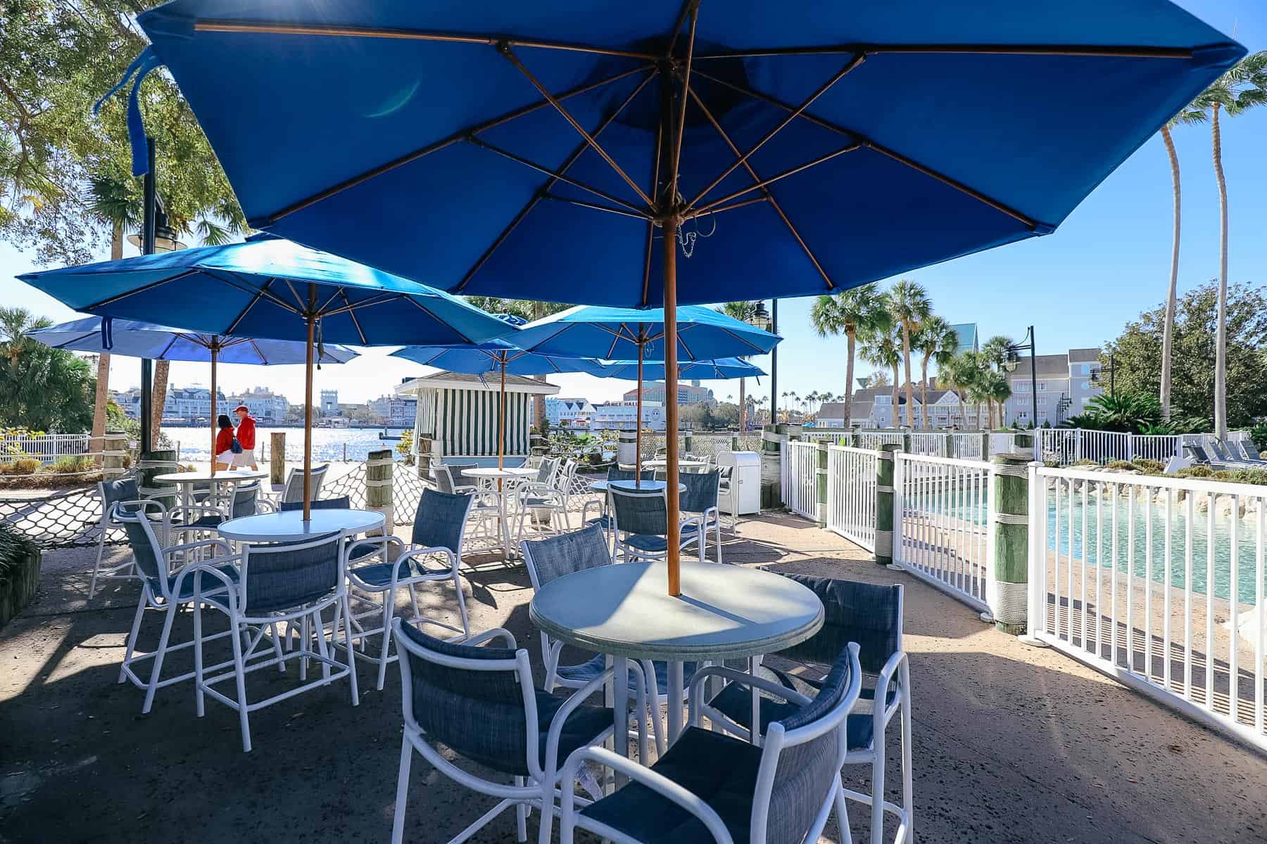 tables and chairs with blue umbrellas at Hurricane Hanna's facing Crescent Lake 