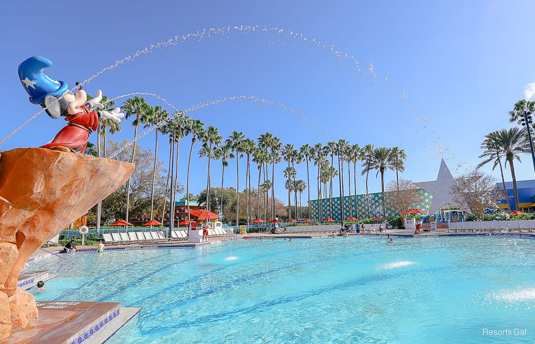 A sorcerer Mickey holds out his hands to spray water into the All-Star Movies Pool. 