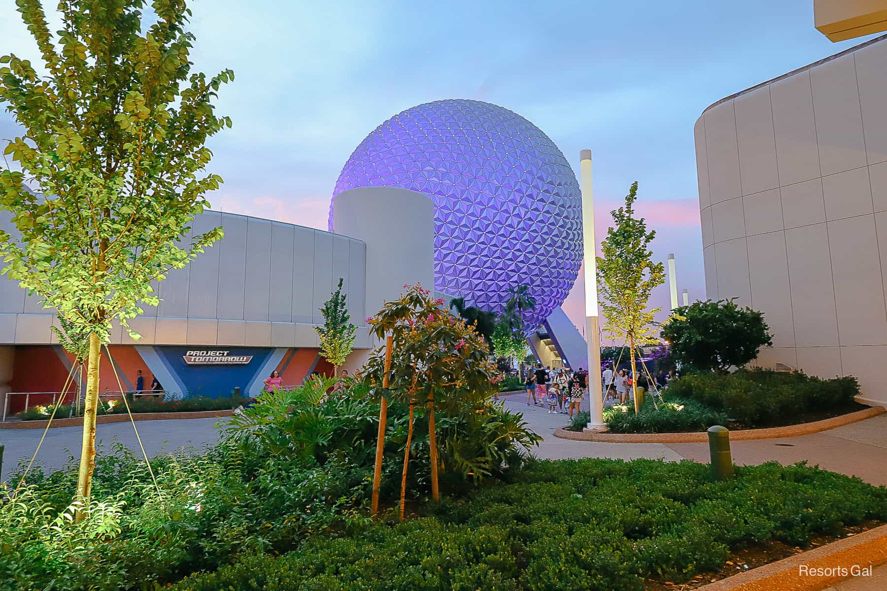 Spaceship Earth glowing in a purple color at sunset with pink accents in the sky. 
