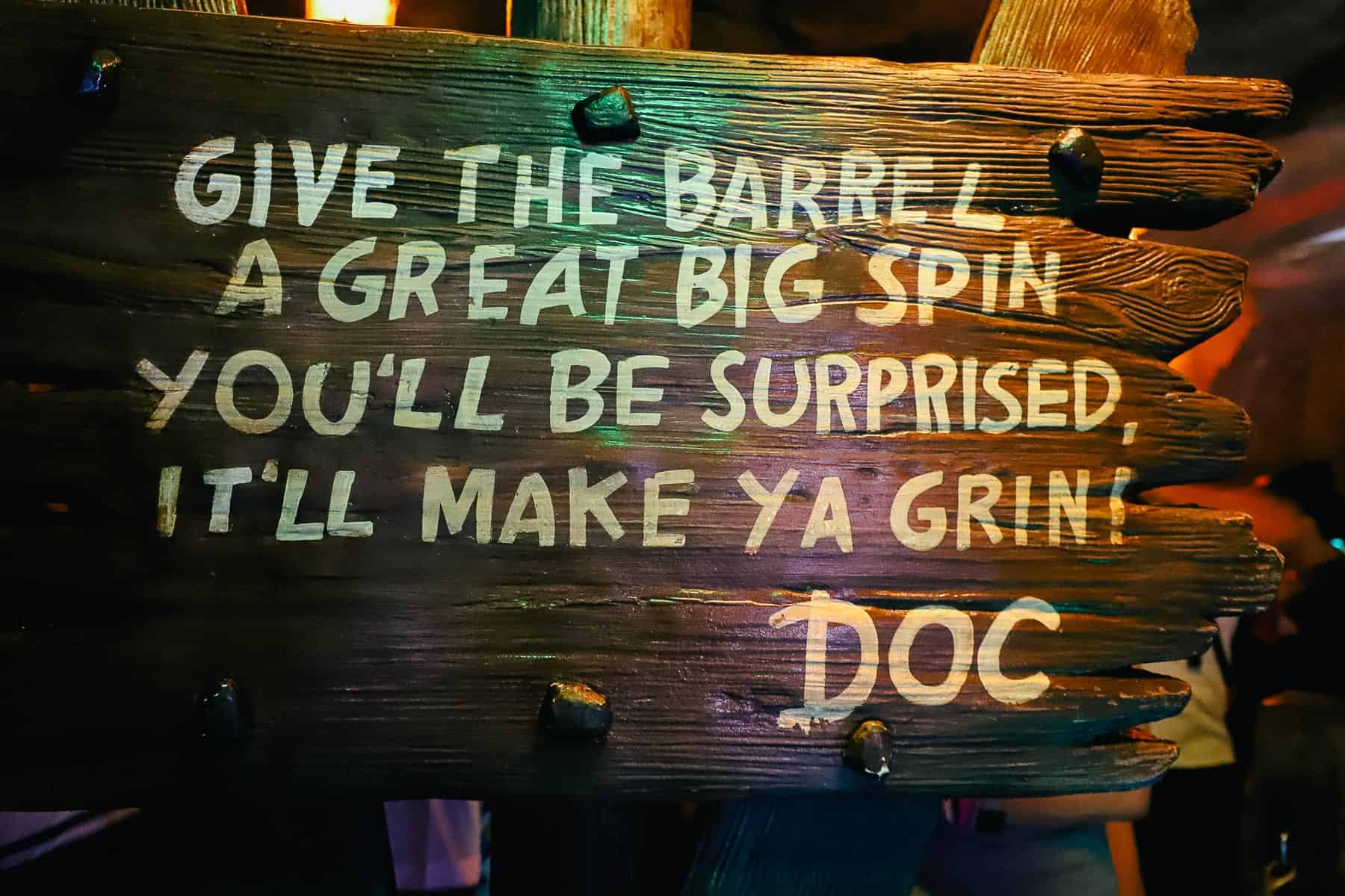 A queue sign that reads "Give the Barrel a great big spin, you'll be surprised, it'll make ya grin." 