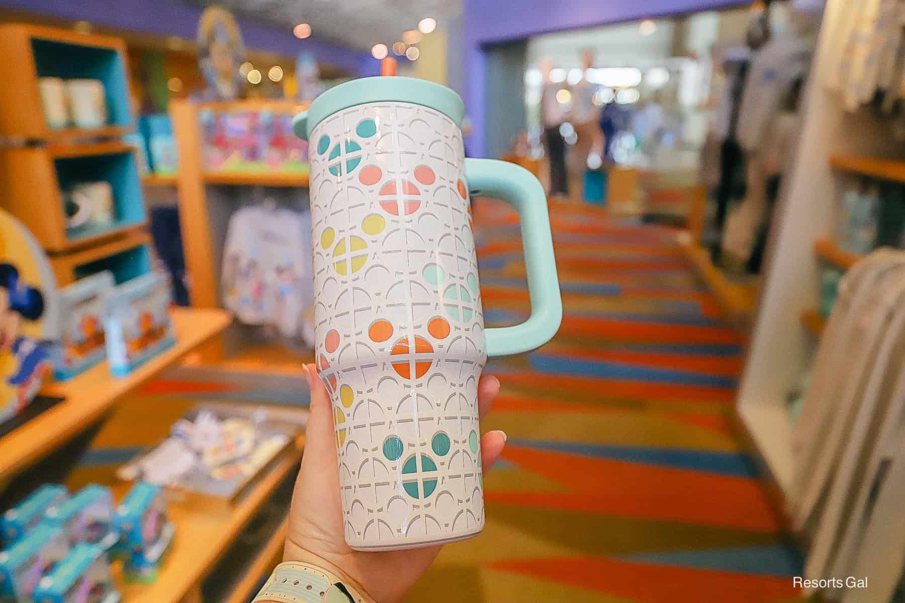 a travel cup with mint green accents and bright hidden Mickey shapes