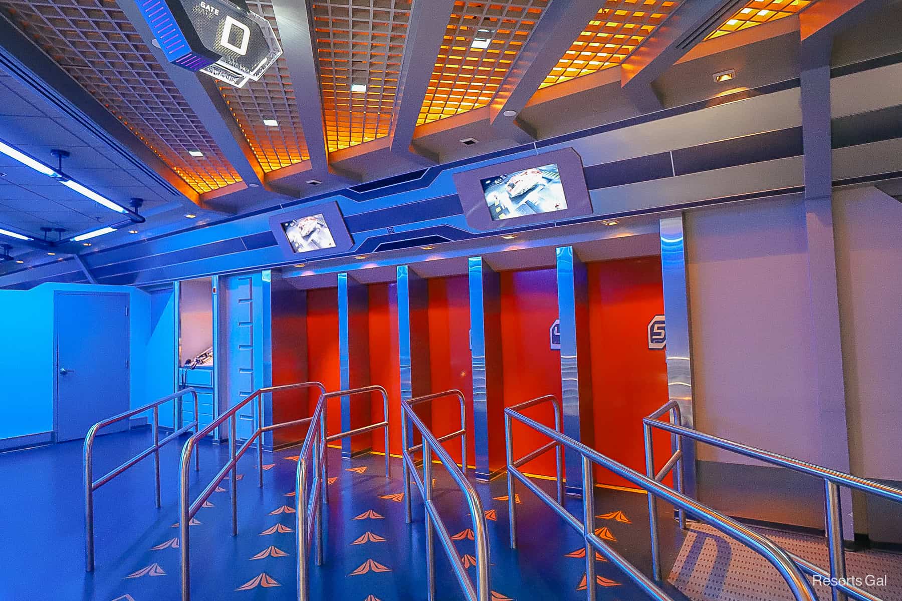 The loading area with five rows in front of red doors where guests wait to ride Star Tours. 