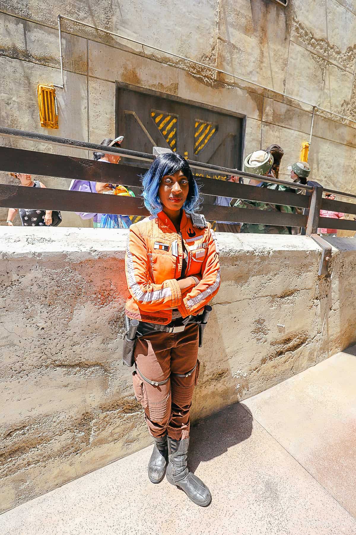 Vi Moradi standing against a wall in Galaxy's Edge. 