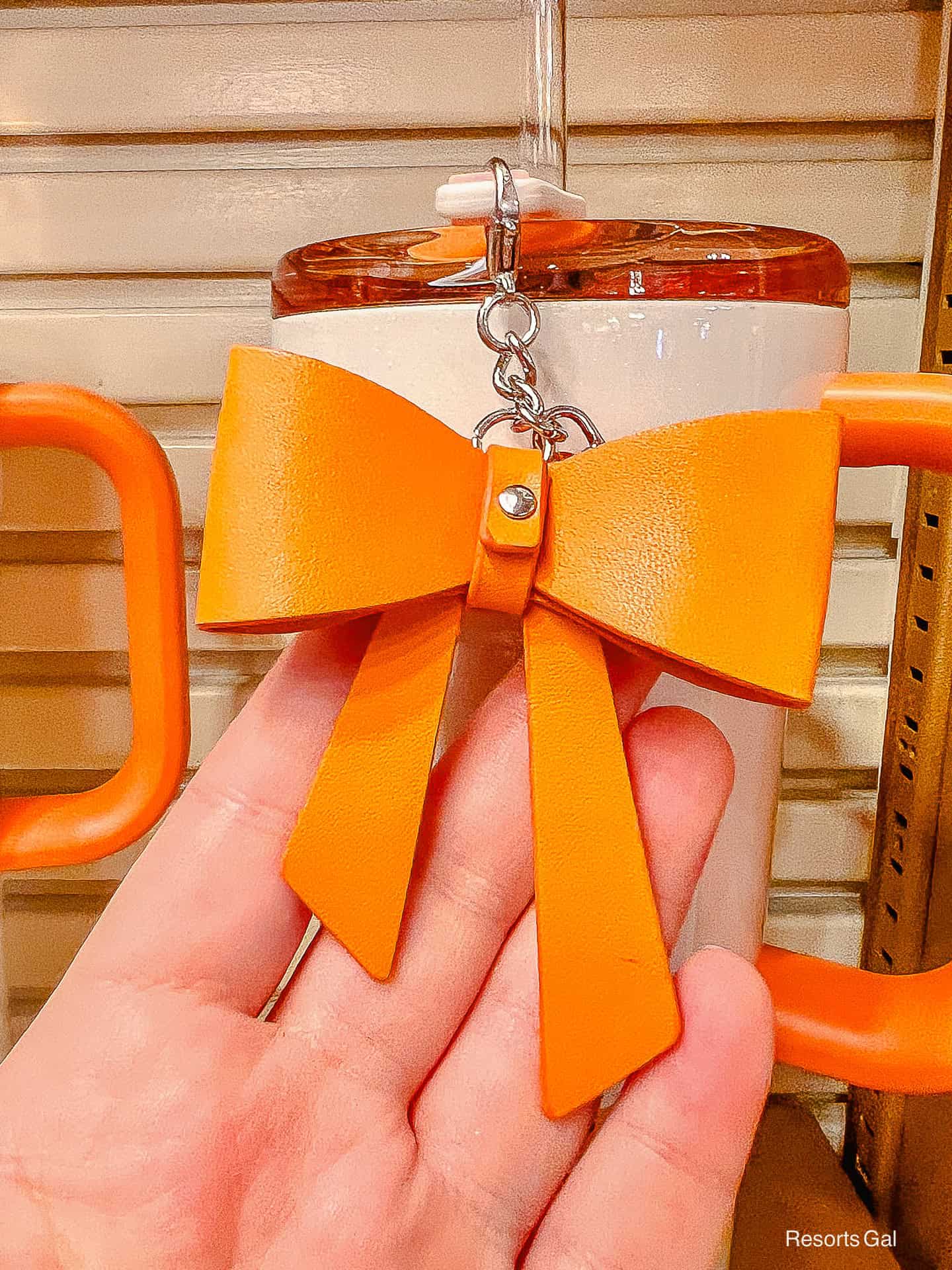 a plastic orange bow on a chain that hangs off the Pumpkin Spice tumber