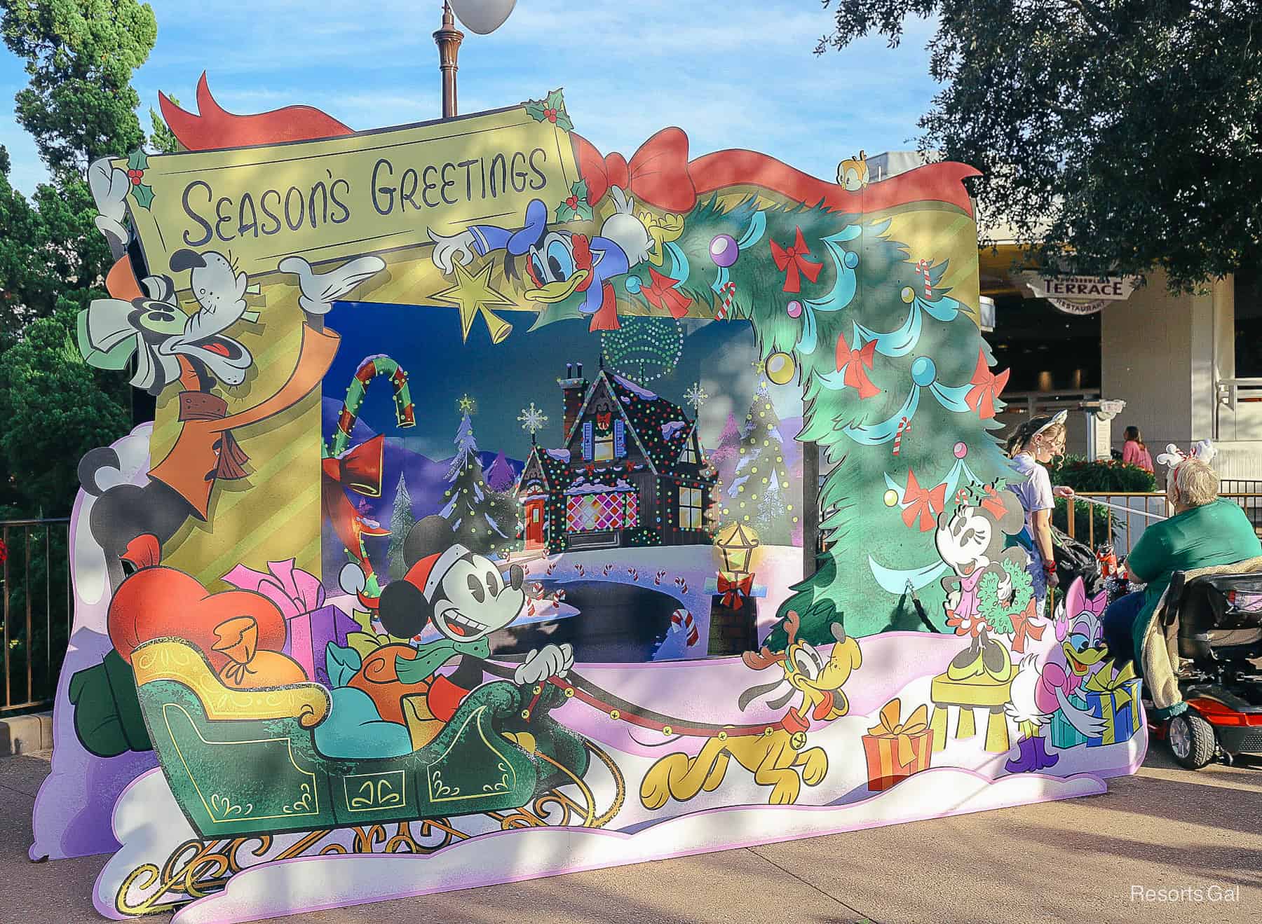 a Season's Greeting Step-In Photo frame in front of Tomorrowland Terrace 