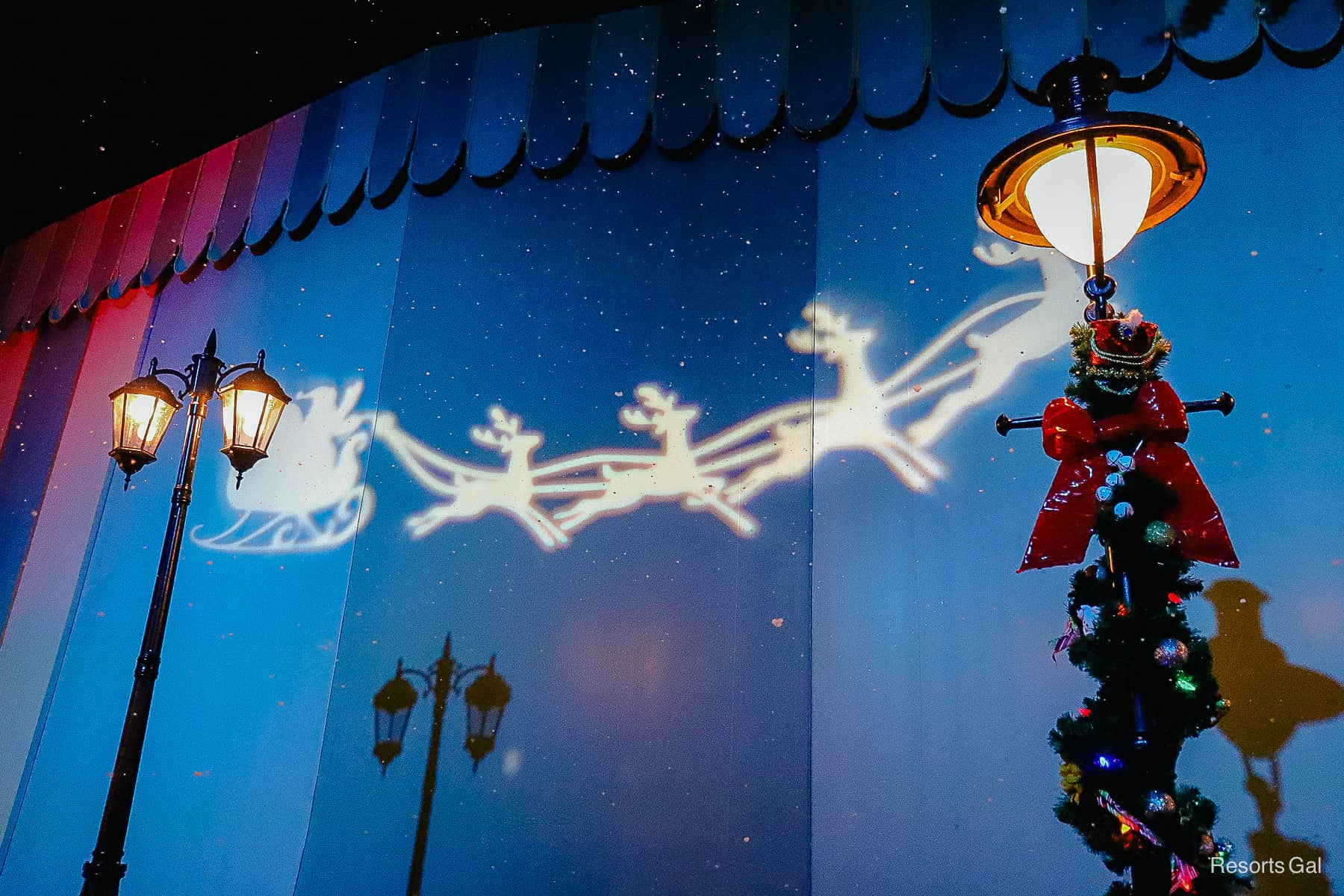 a holiday projection with Santa Clause's sleigh being pulled by reindeer