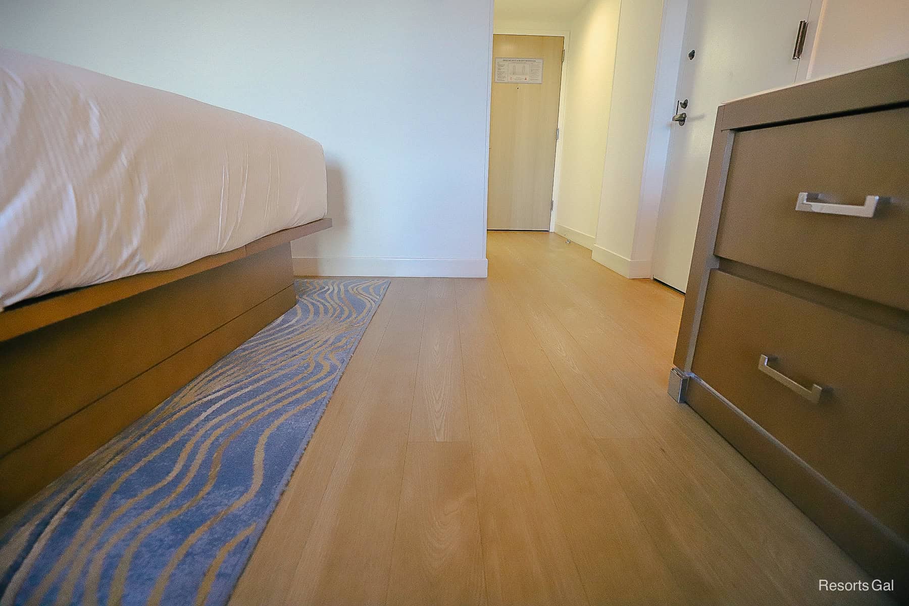 shows the solid surface flooring in the room with a rug in the bed area 