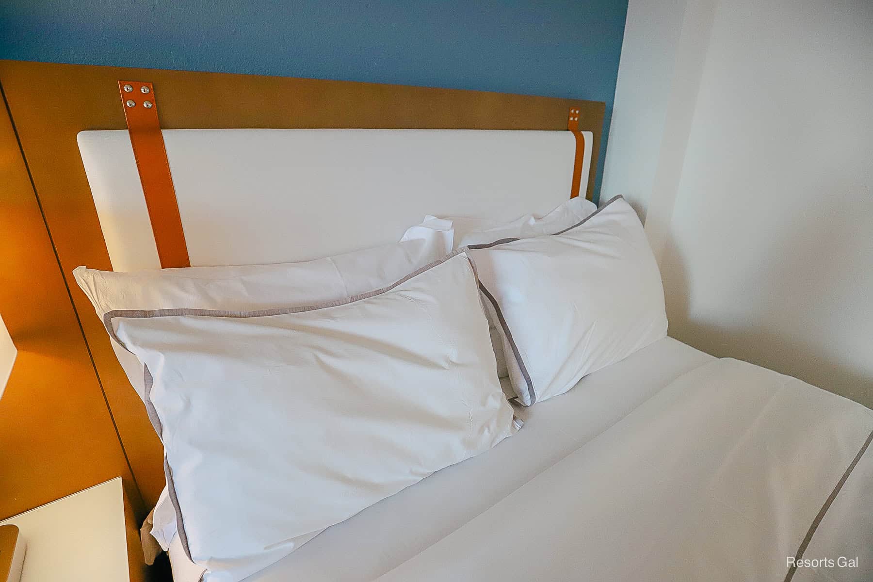 a closeup of the cushioned leather headboard with pillows stacked against it in the Swan Hotel 