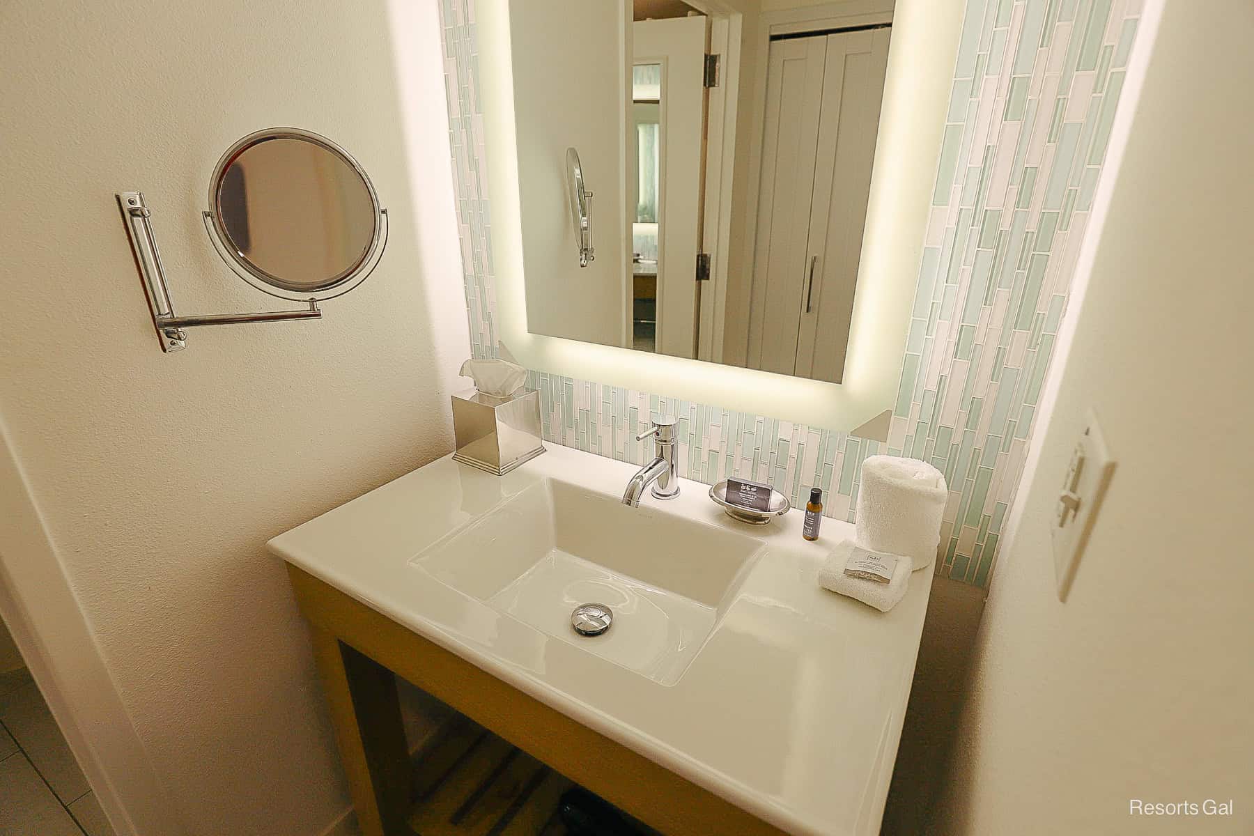 the vanity features a sink, toiletries, and a mirror 