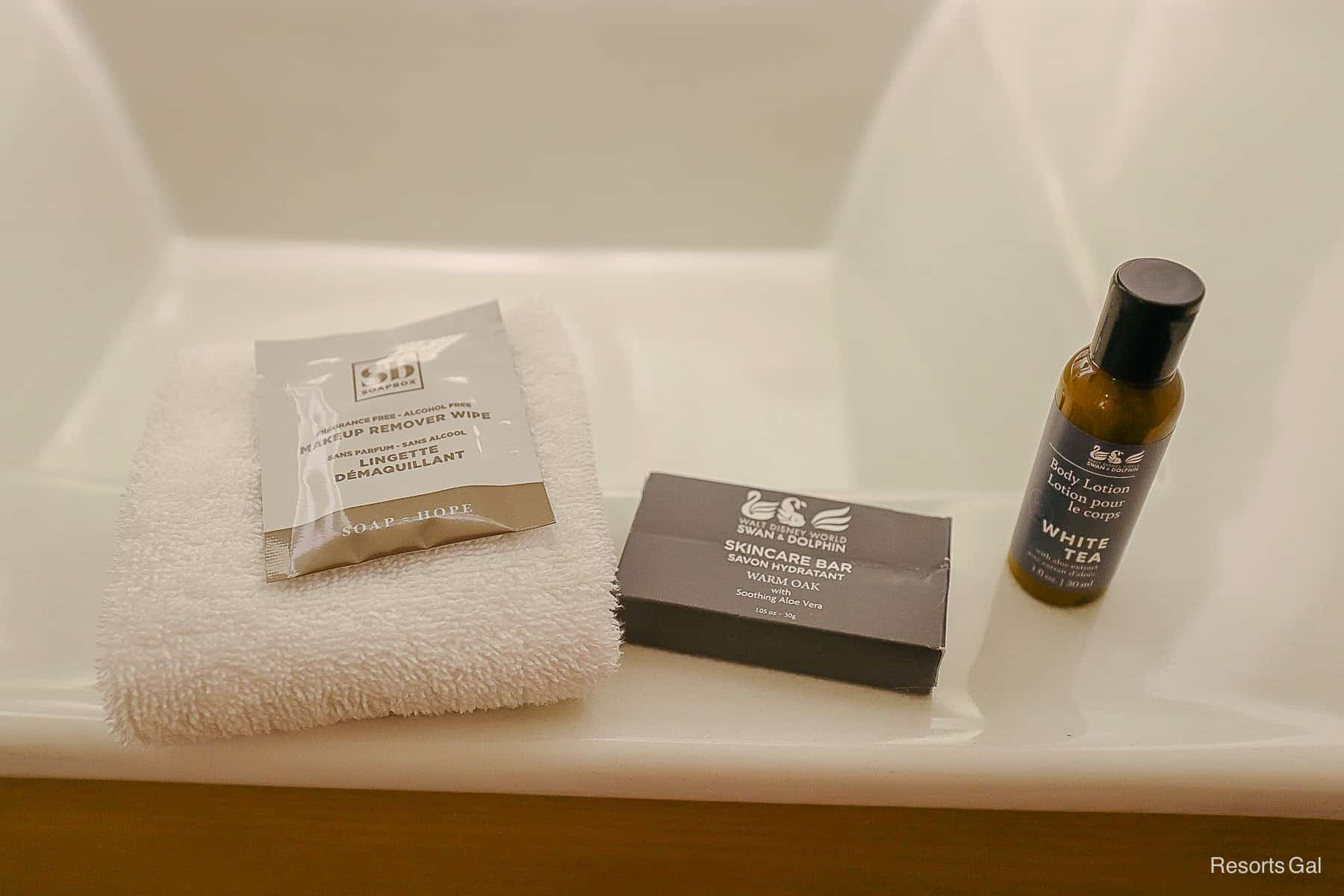 a makeup remover package, a skincare bar, and a bottle of lotion 