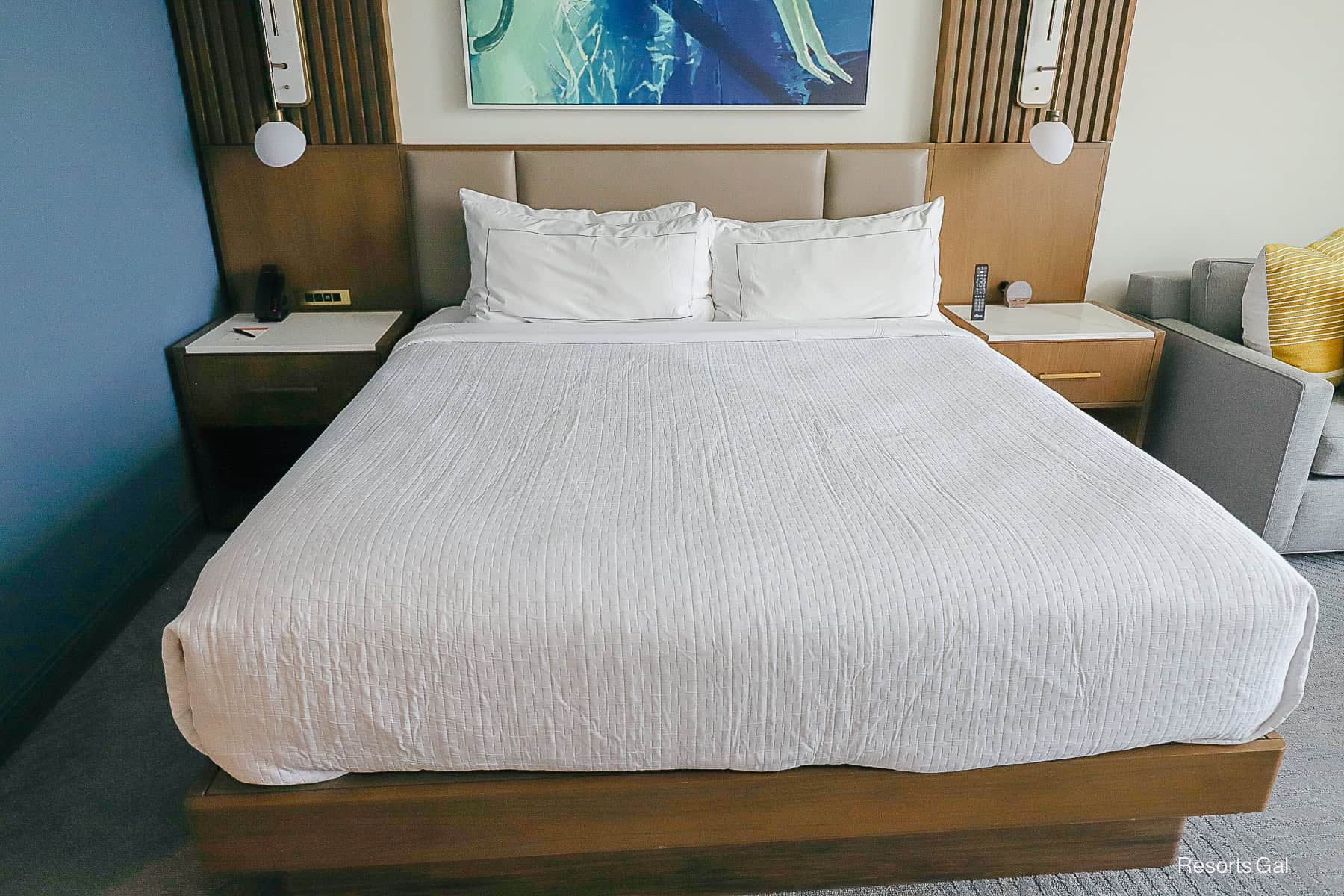 a platform style hotel bed with all white linens at the Walt Disney World Swan Reserve