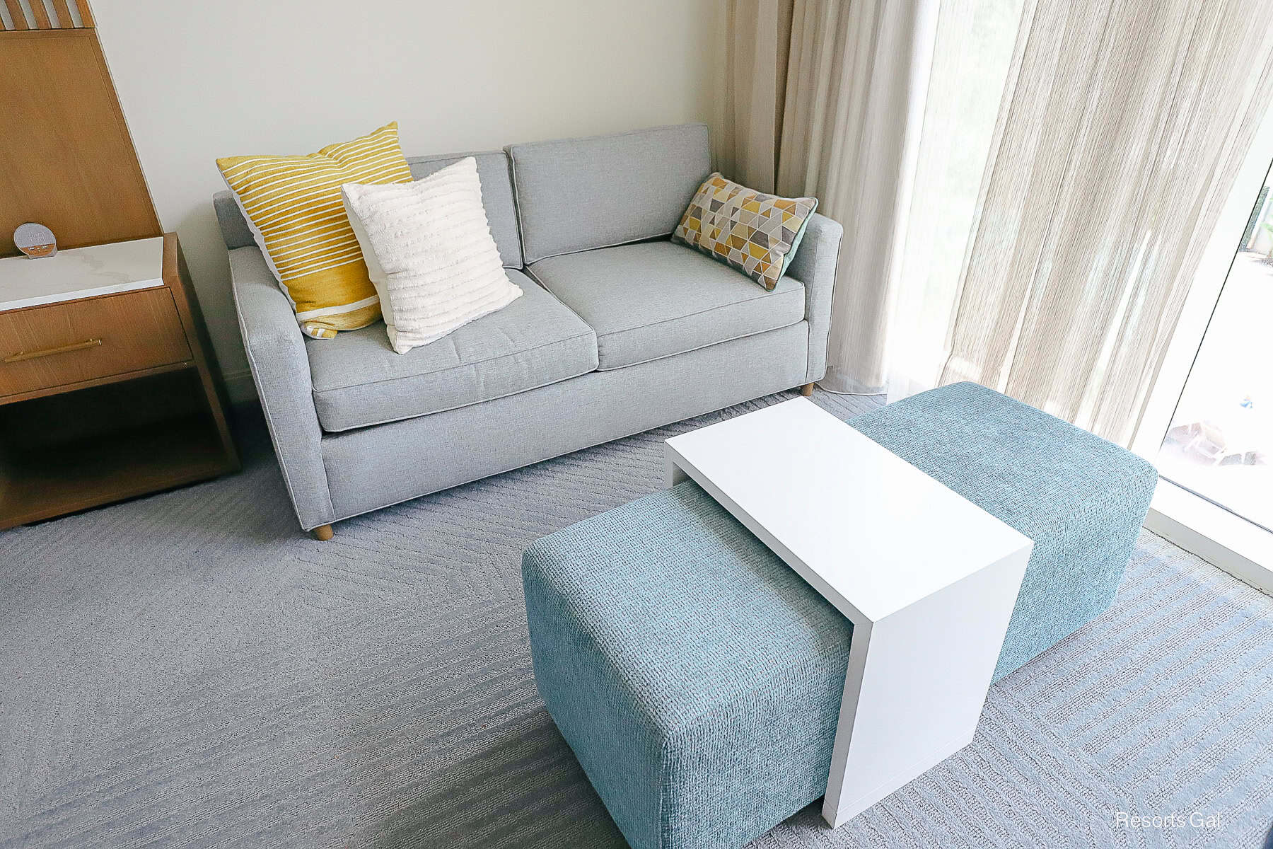 a sofa with ottoman and tv tray in the Swan Reserve Hotel Room
