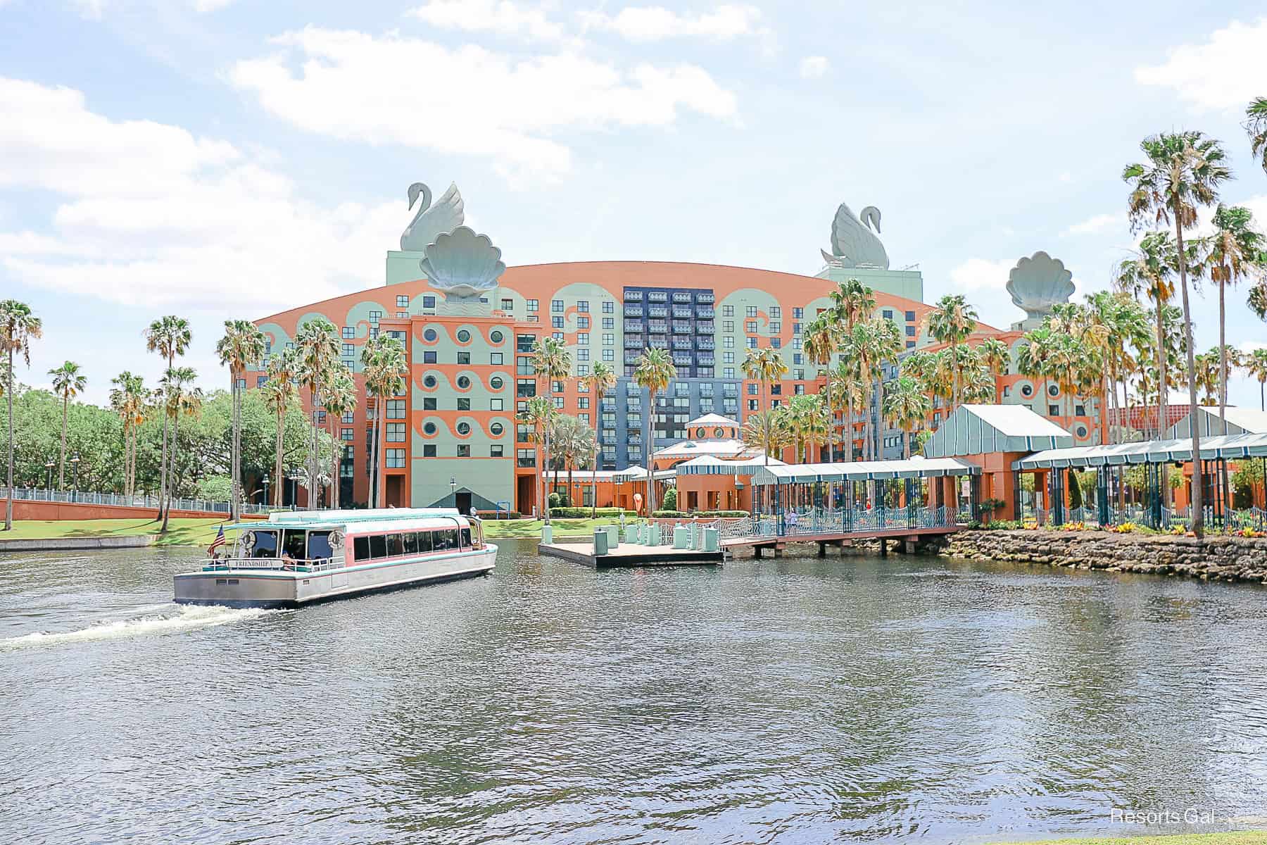 Swans perched on the hotel with the boat docking nearby.