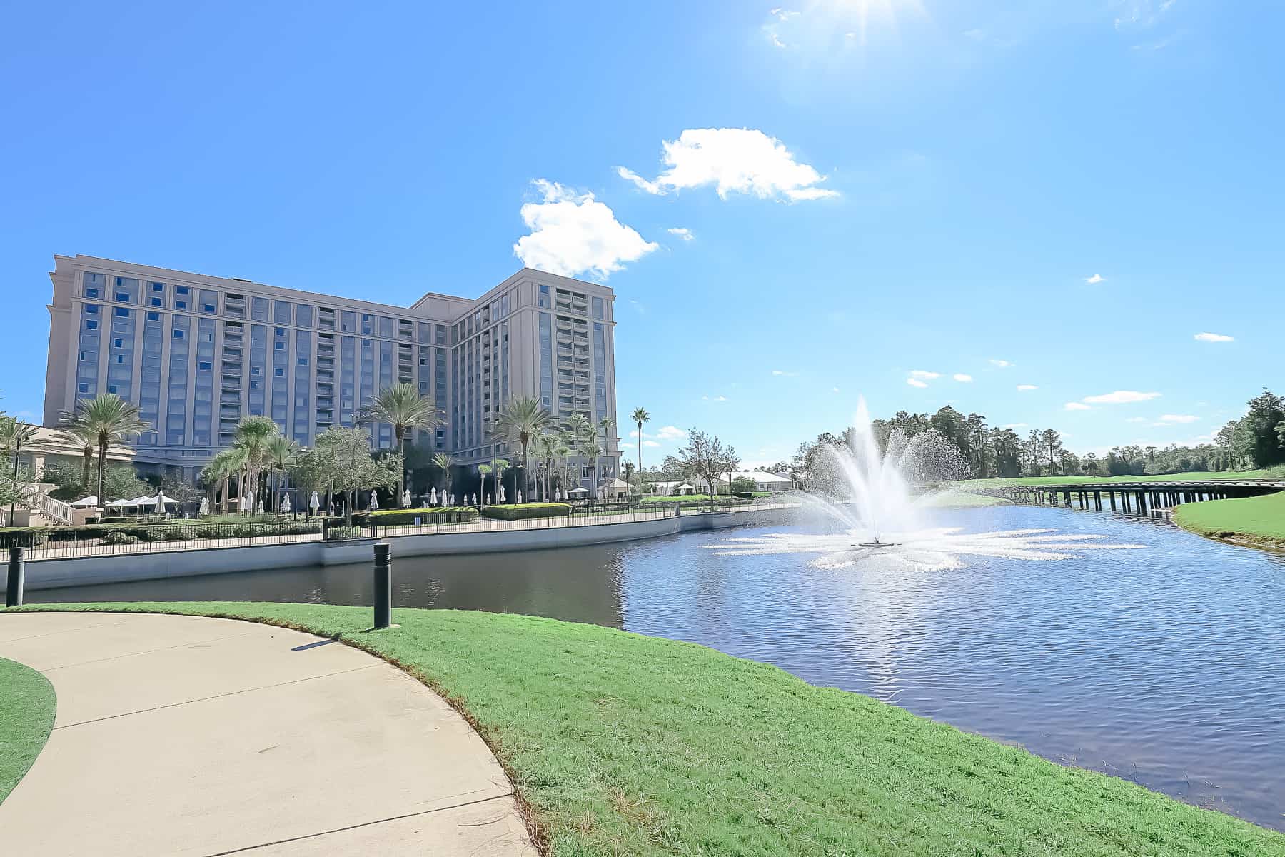 The back side of the Waldorf Orlando with a fountain in the lake. 