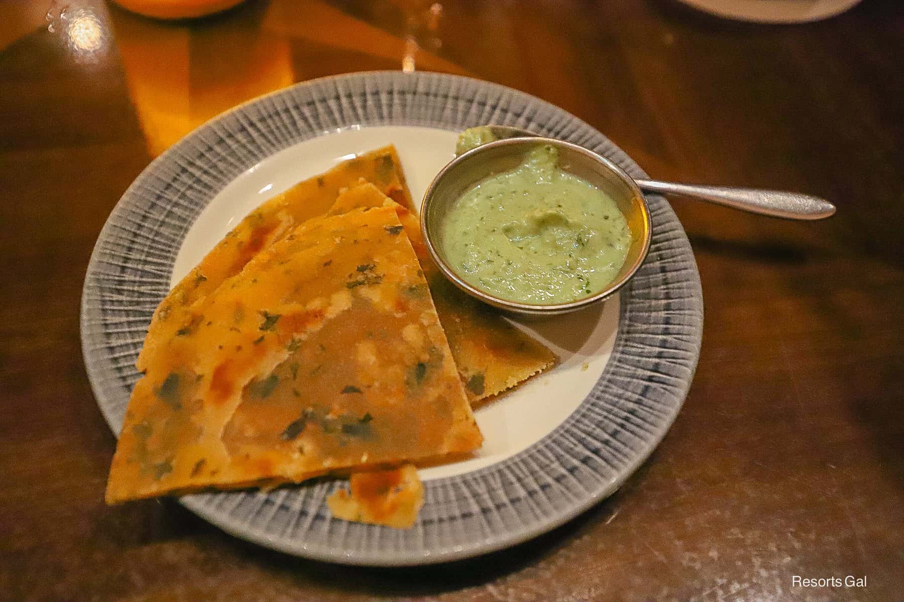 a plate with triangle bread service and a green sauce 